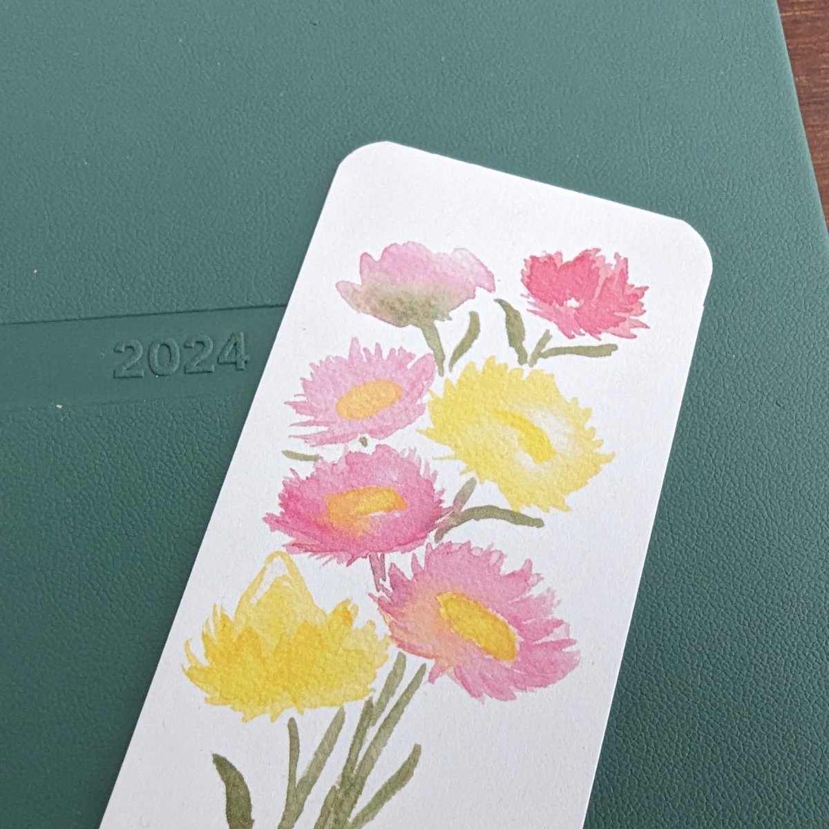 Bookmark pink and yellow everlasting daisy-on notebook close up1.jpg