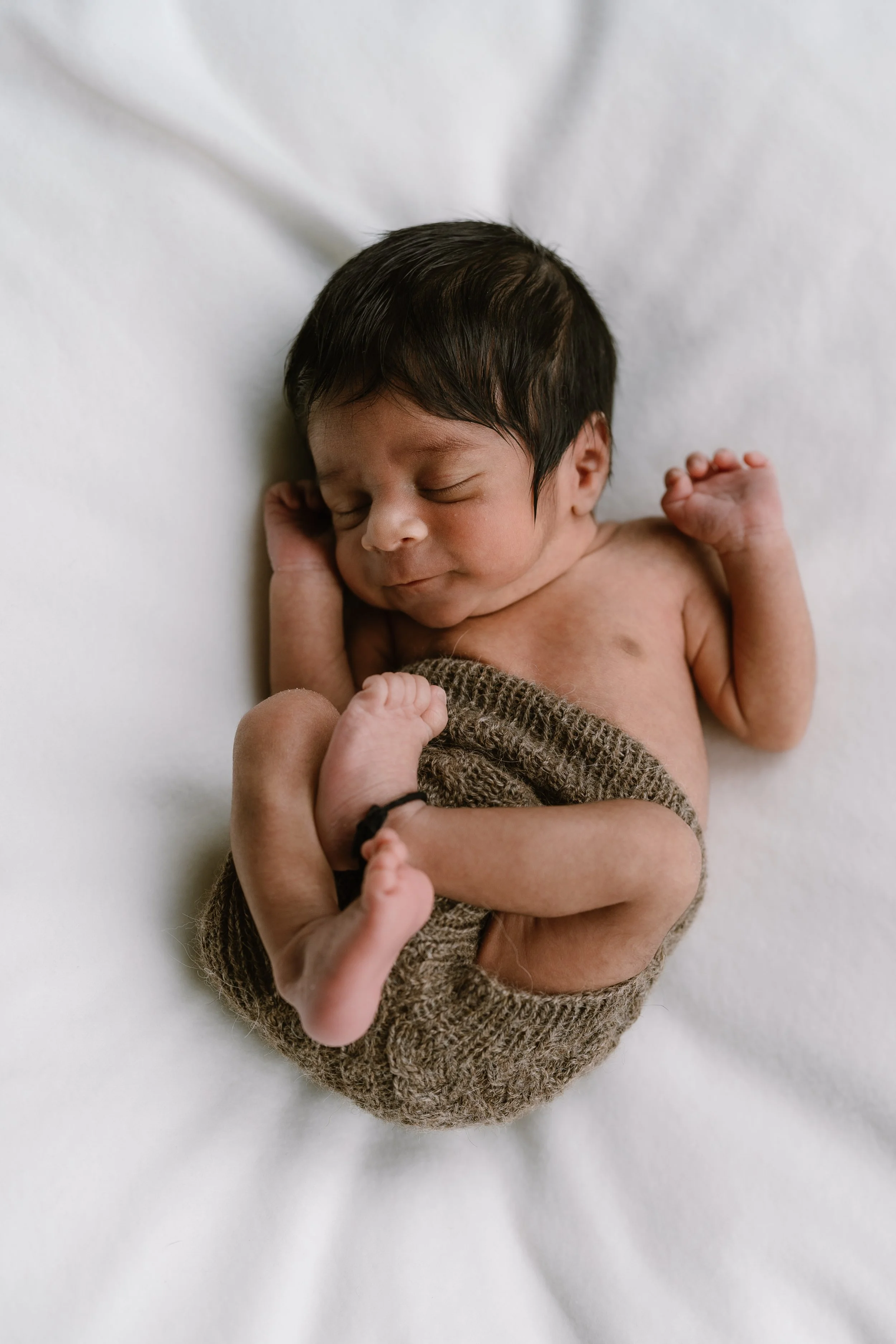 Curled up newborn fast asleep
