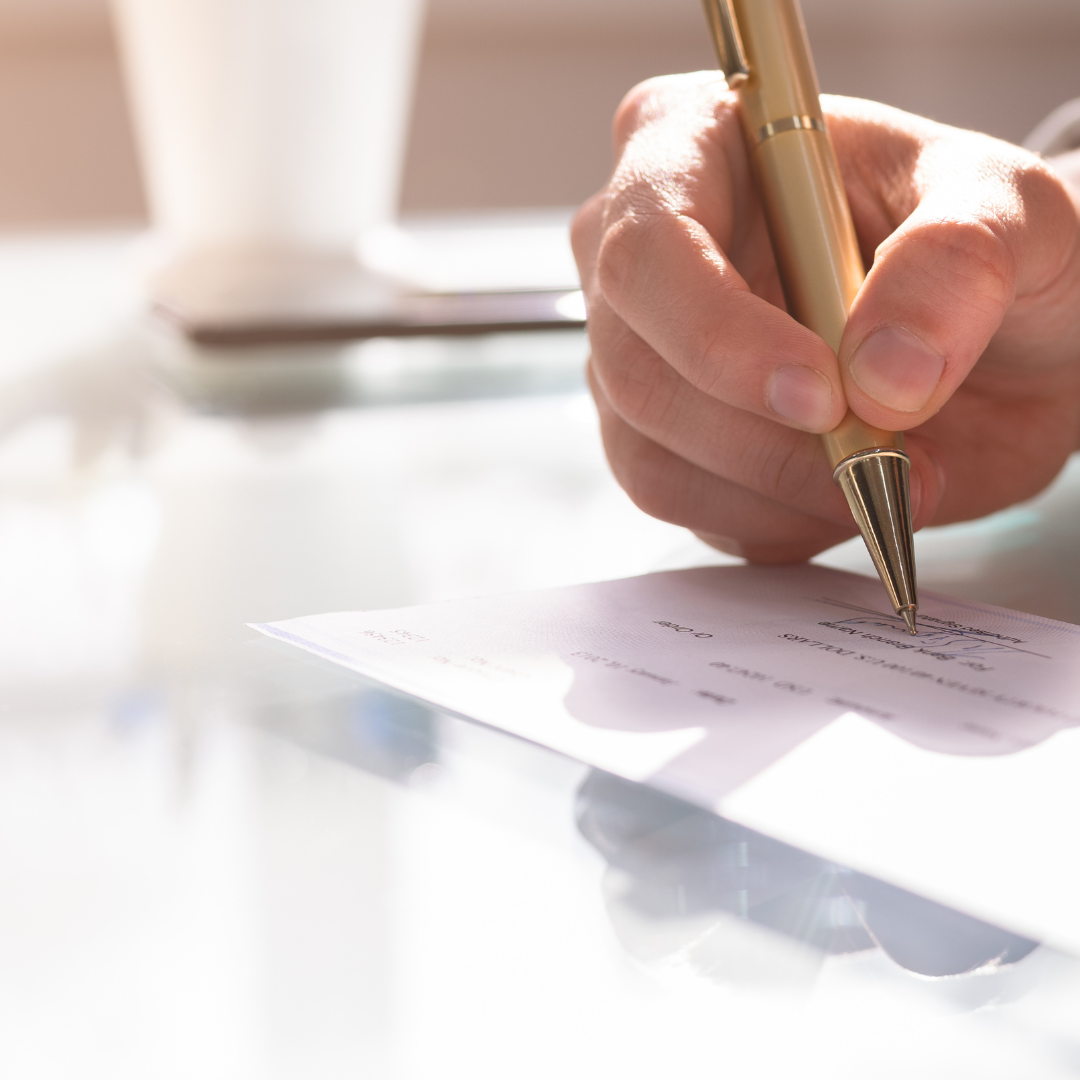 business owner signing a payroll check