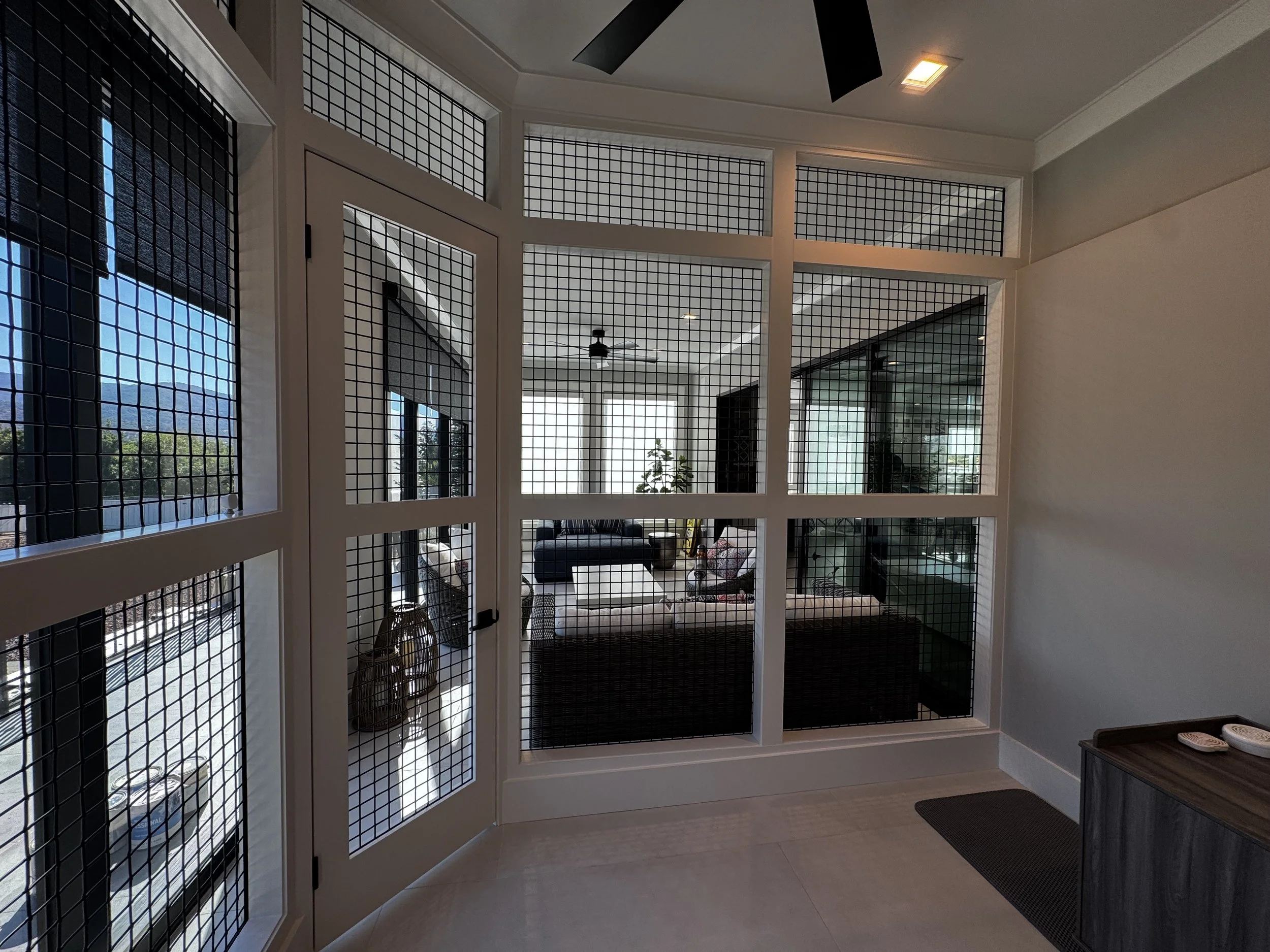 Custom interior catio with architectural mesh panels.