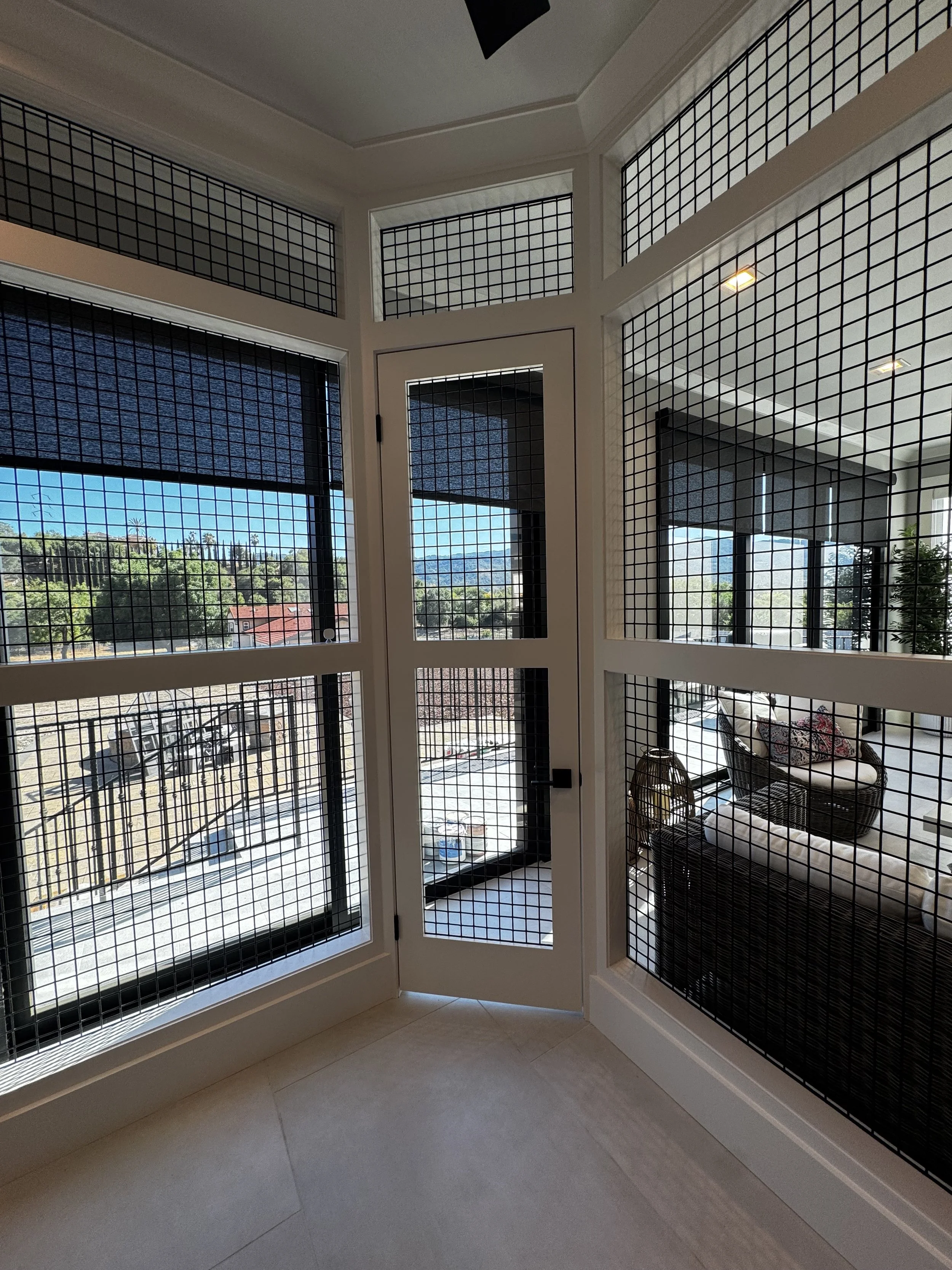 Custom interior catio with architectural mesh panels.
