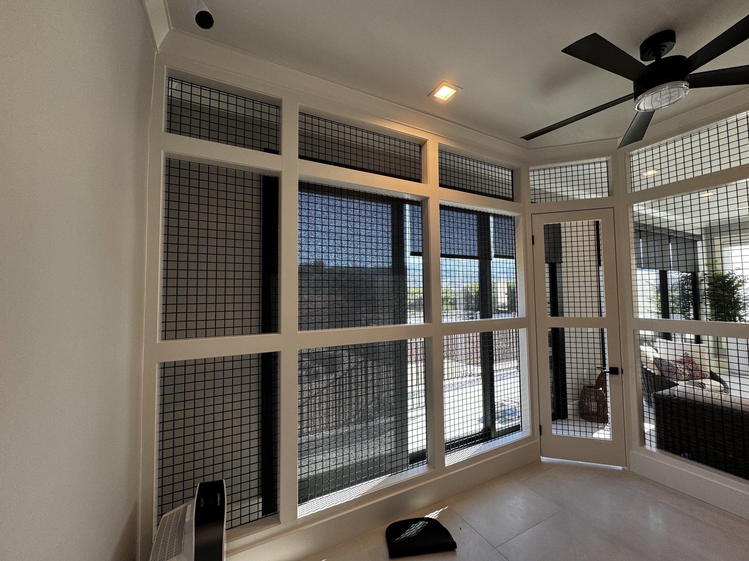 Custom interior catio with architectural mesh panels.