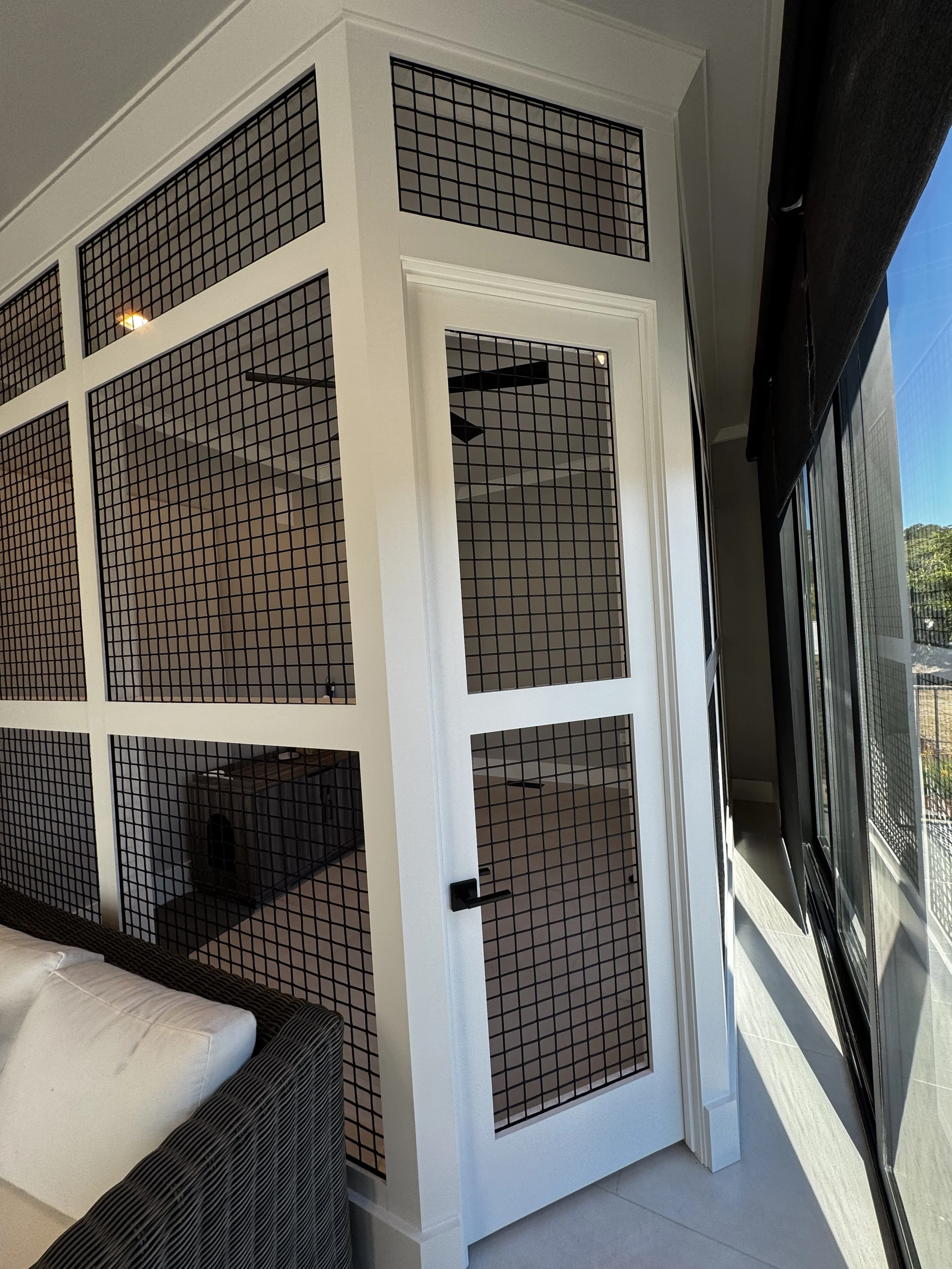 Custom interior catio with architectural mesh panels.