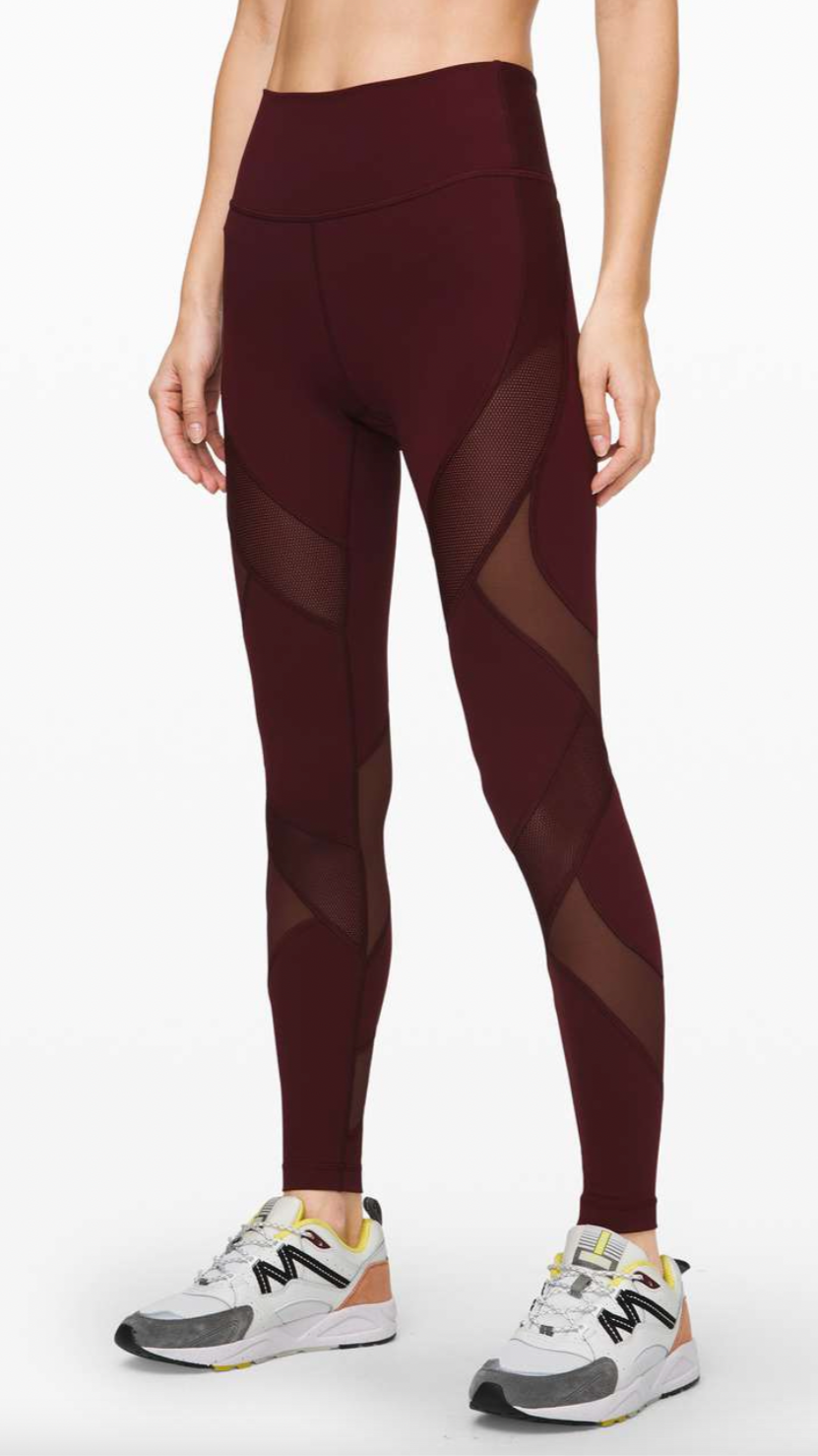 Maroon athletic leggings with mesh panels and sneakers.