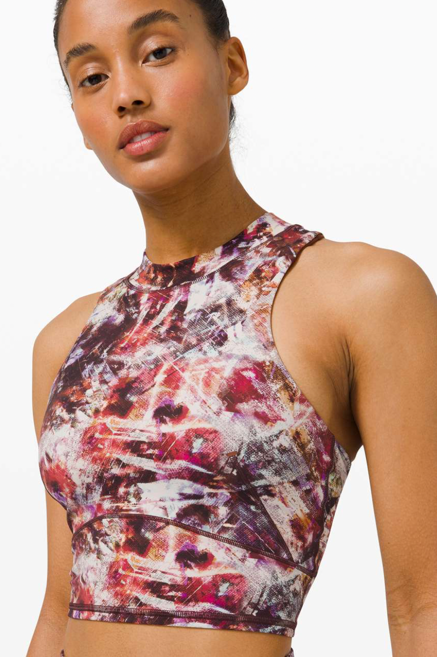 A woman wearing a colorful, abstract-patterned sleeveless athletic top.