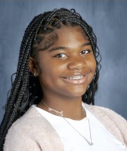 Close up of Aubrie smiling in a white T-shirt and tan cardigan
