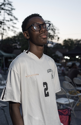 Medium shot of Pochette posed in a three-quarters shot facing the camera wearing a white sports jersey