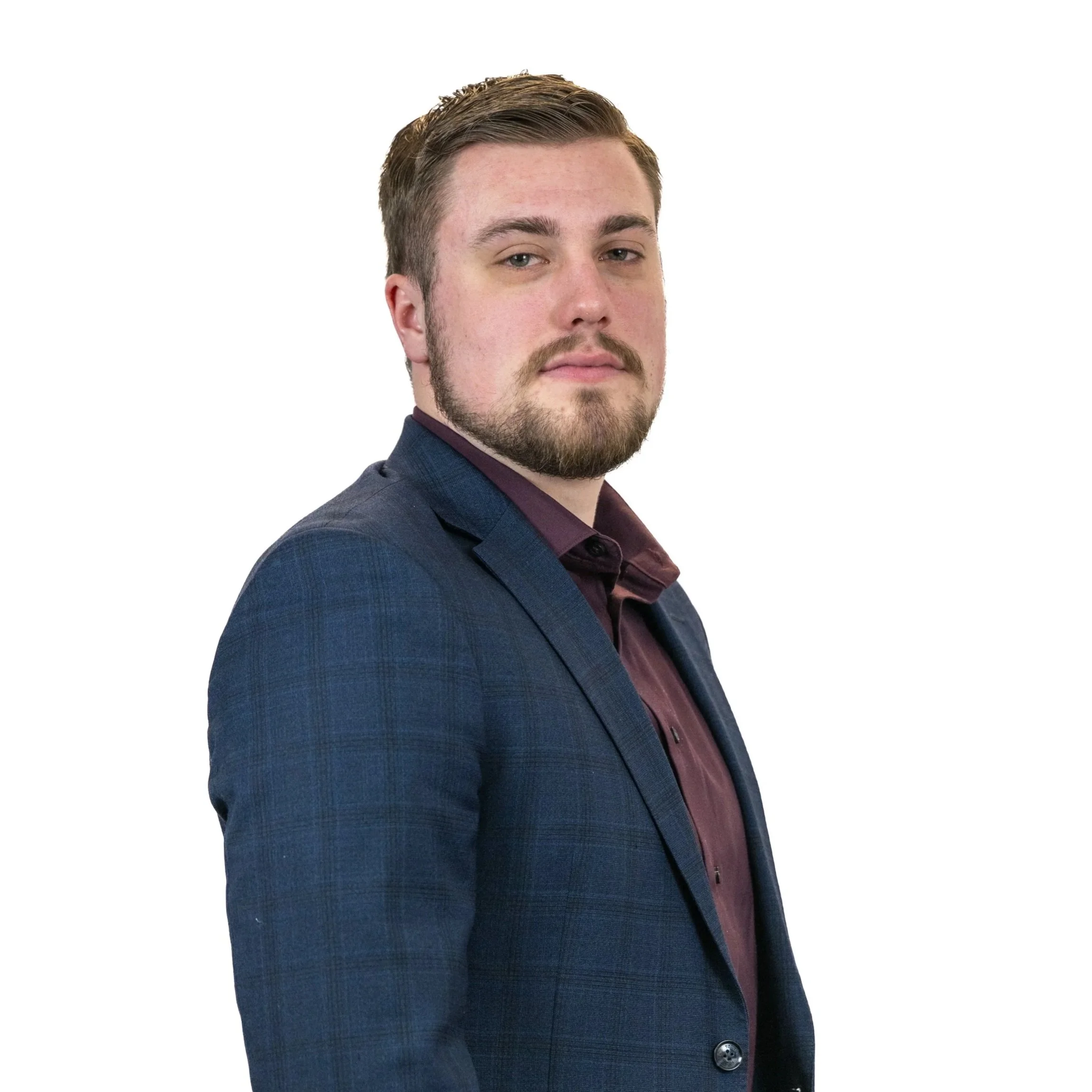 A portrait of a man with short brown hair and a beard, wearing a navy blue blazer and a dark maroon shirt, against a white background.