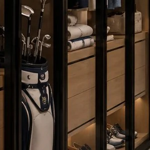 Blue World Voyages penthouse walk-in closet concept with illuminated glass wardrobes leading to the primary bathroom.