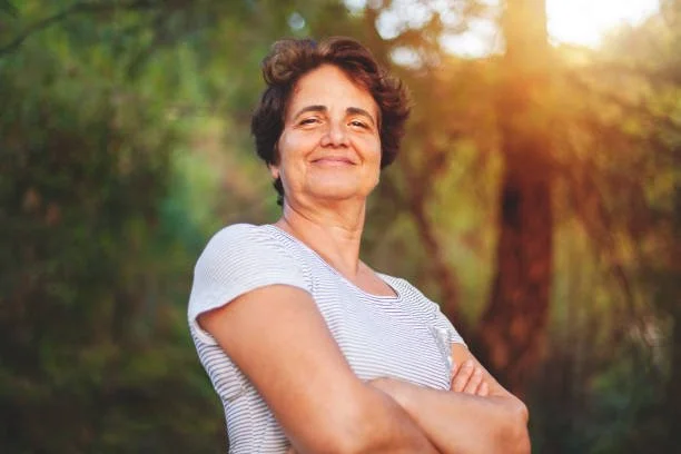 Middle aged women crossing her arms while smiling 