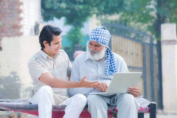 One middle aged man showing something on the computer to a older adult male