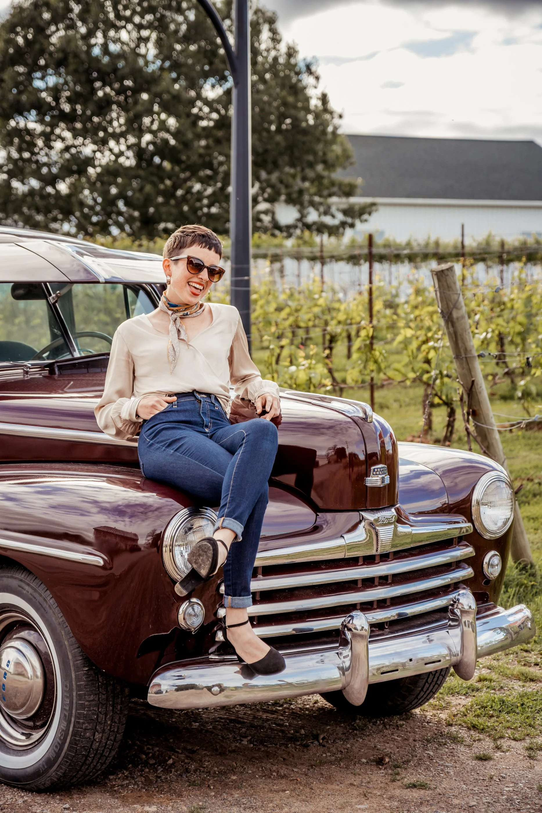A guest sit and laughs on the hood of our 1947 Ford. 