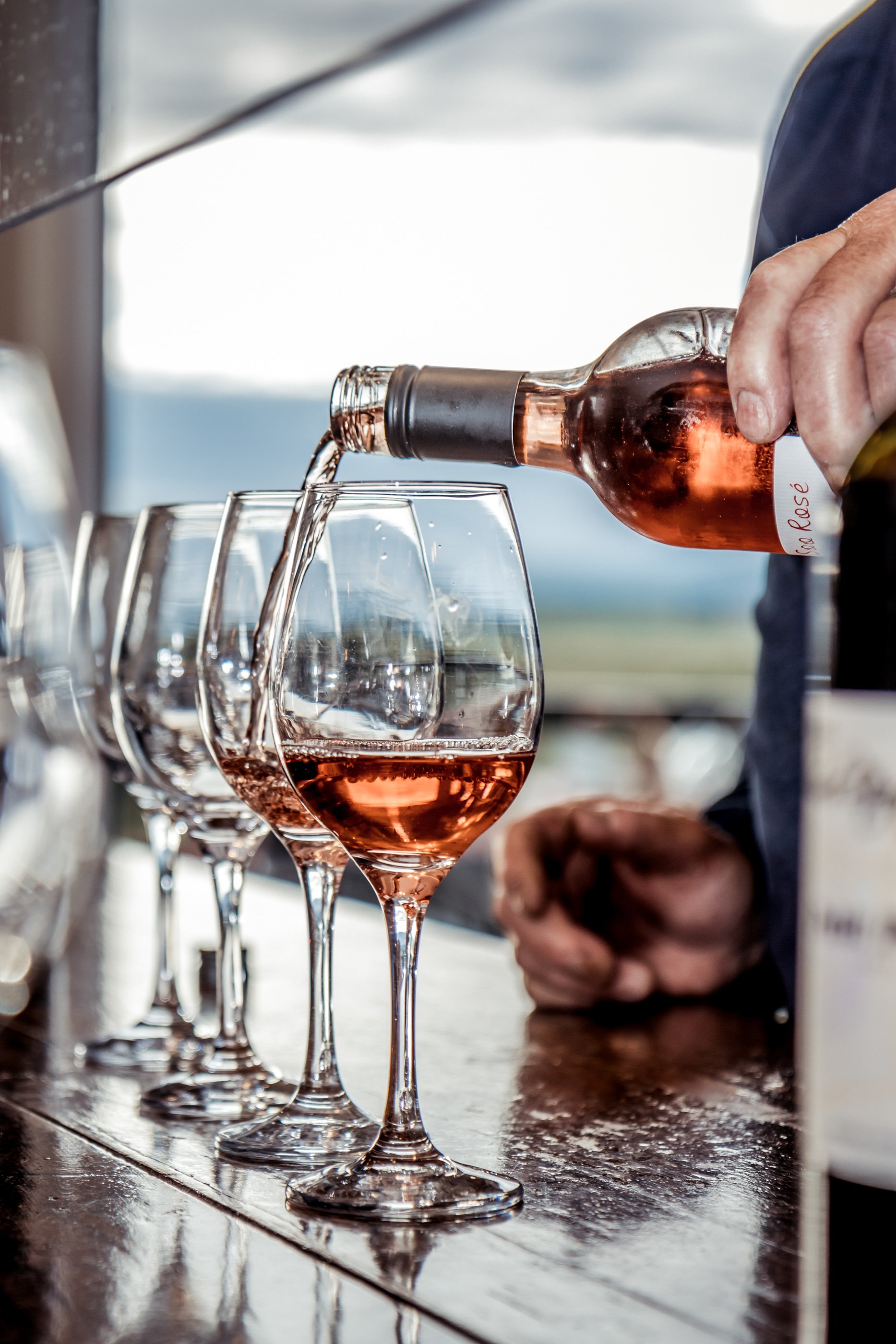 A winemaker pours a glass of rosé.
