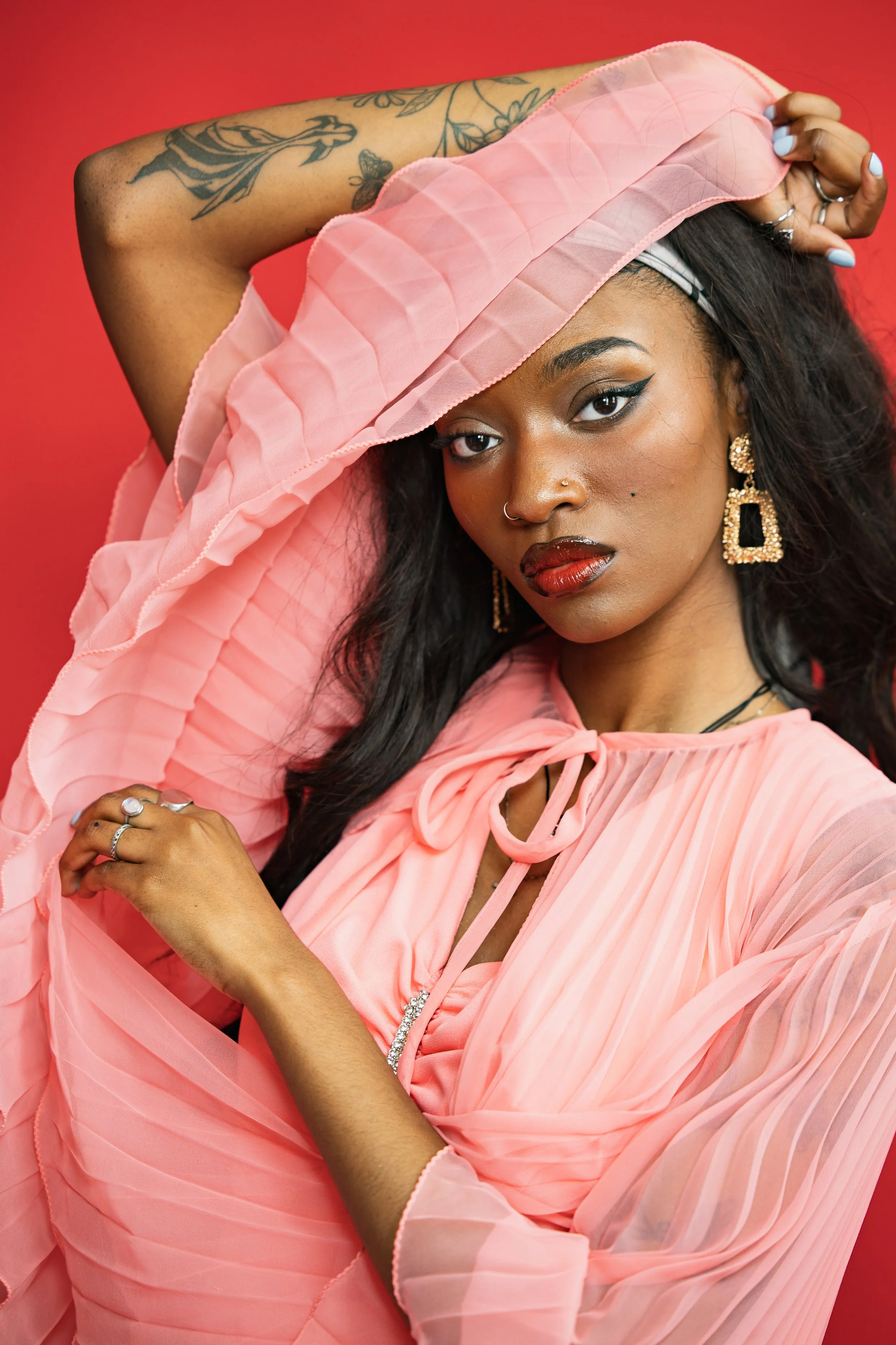 A woman posed against a red background in Cincinnati commercial photography  studio