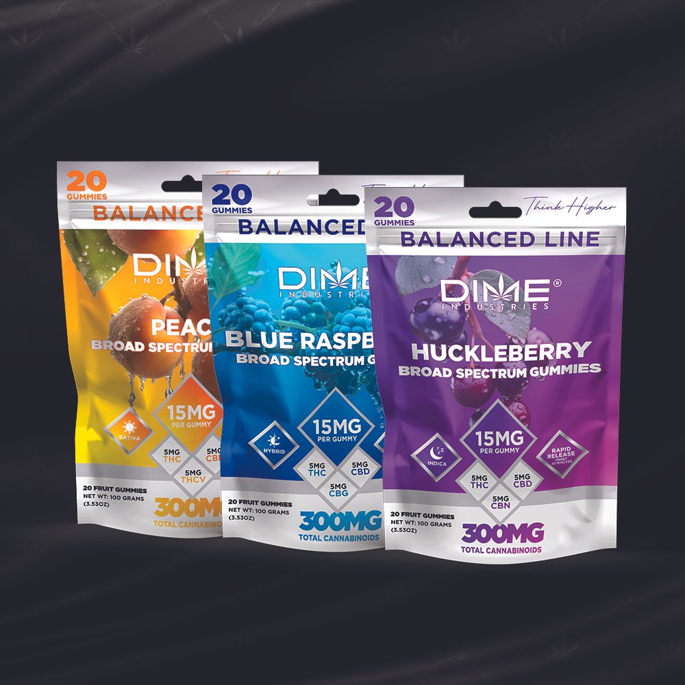 Three packages of DIME Industries broad spectrum gummies in peach, blue raspberry, and huckleberry flavors with 15mg THC per gummy.
