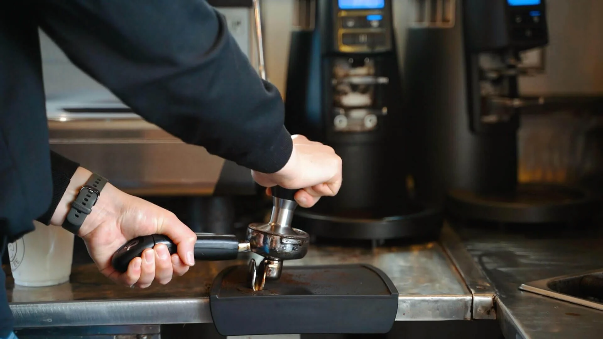 Arrowhead Coffee worker pressing a shot of espresso.
