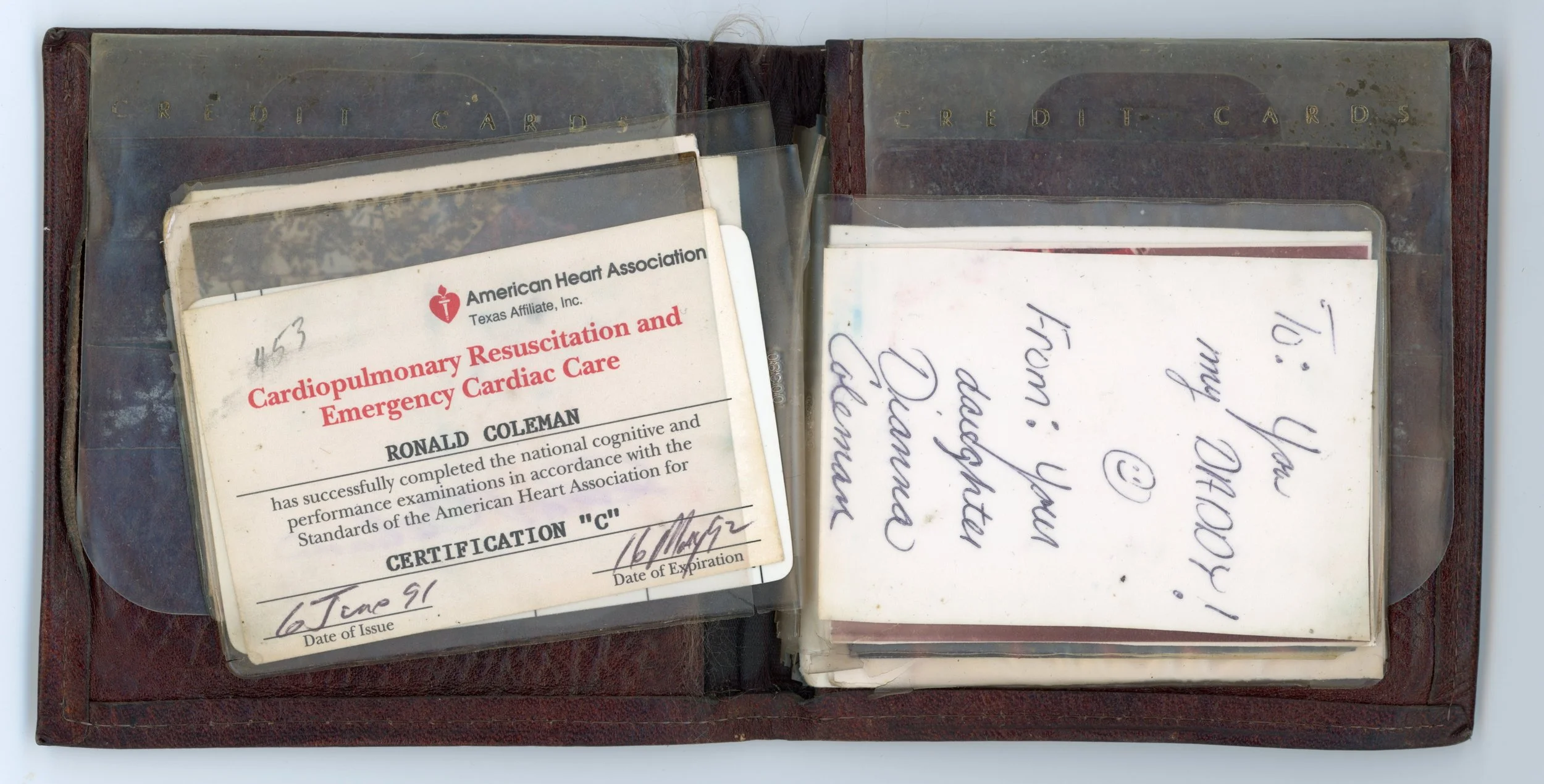 Old leather binder containing vintage medical cards, including one titled 'Cardiopulmonary Resuscitation and Emergency Cardiac Care' for Ronald Coleman, with handwritten notes and signatures.