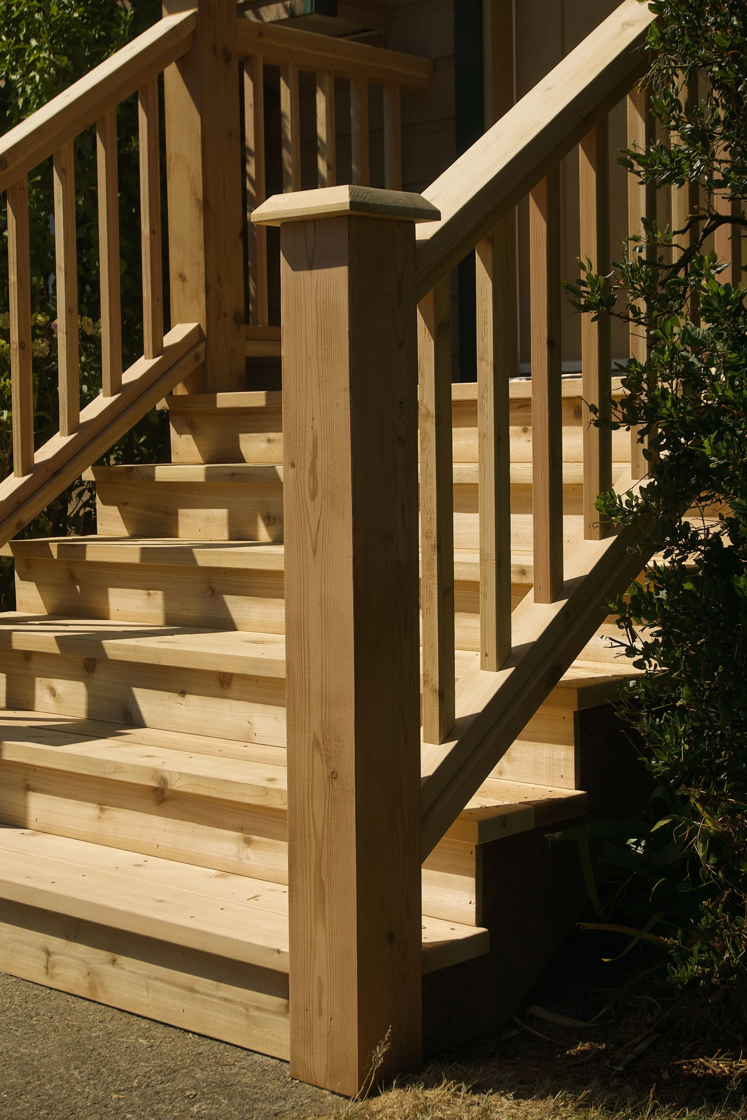 Red cedar newel post with cap. Front entryway stairs with railings and spindles in Sidney, BC