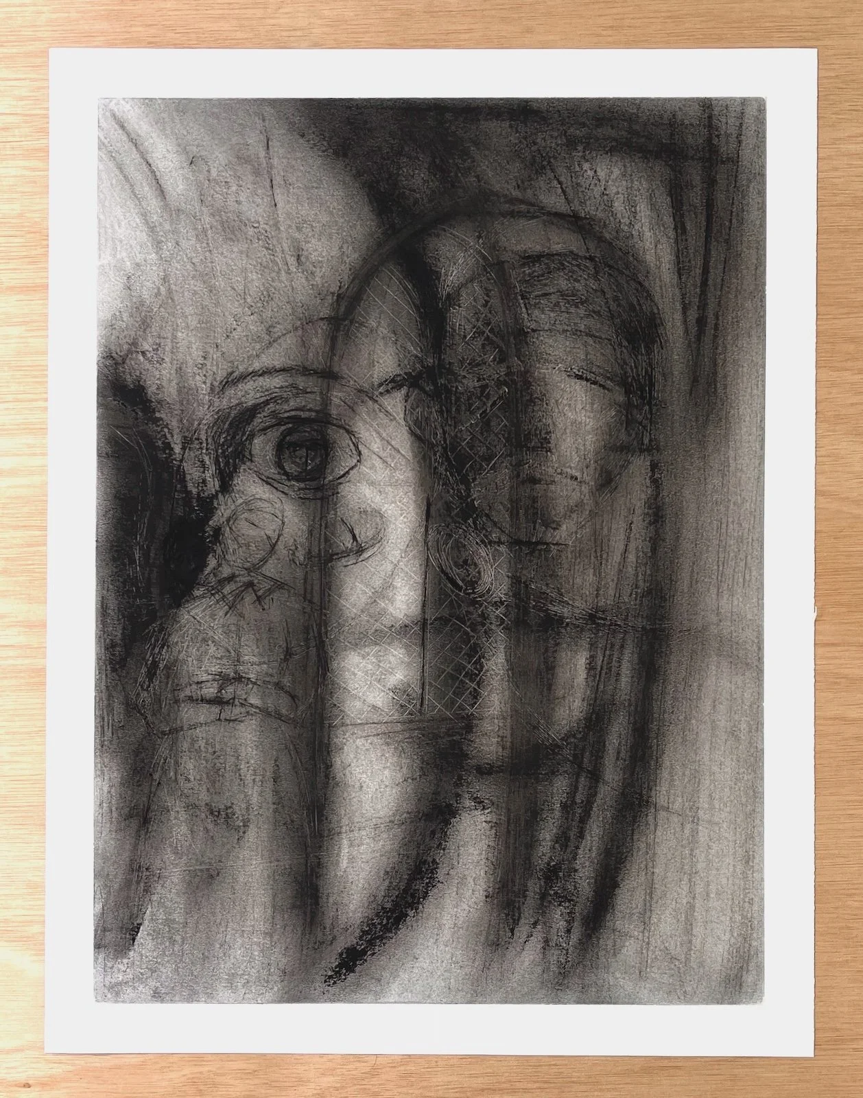 Full sheet view of a charcoal drawing depicting overlapping faces and a leaded window, with visible paper edges.