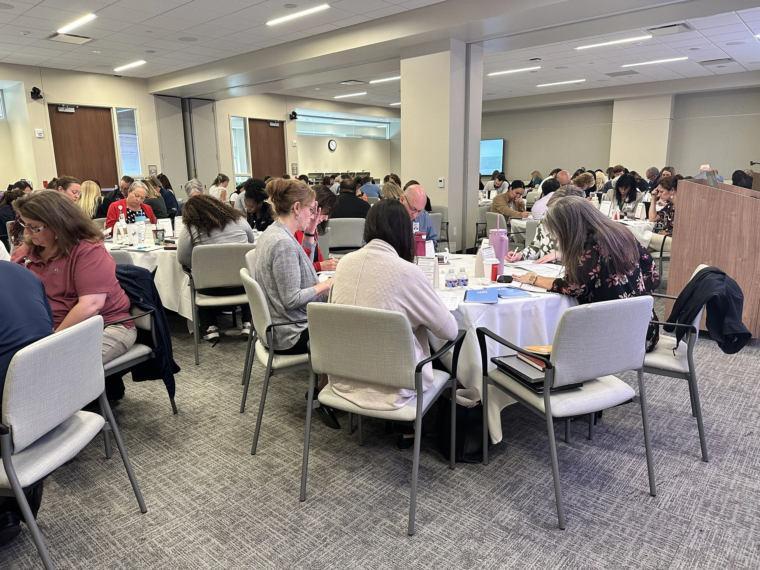team working in small groups in large conference room