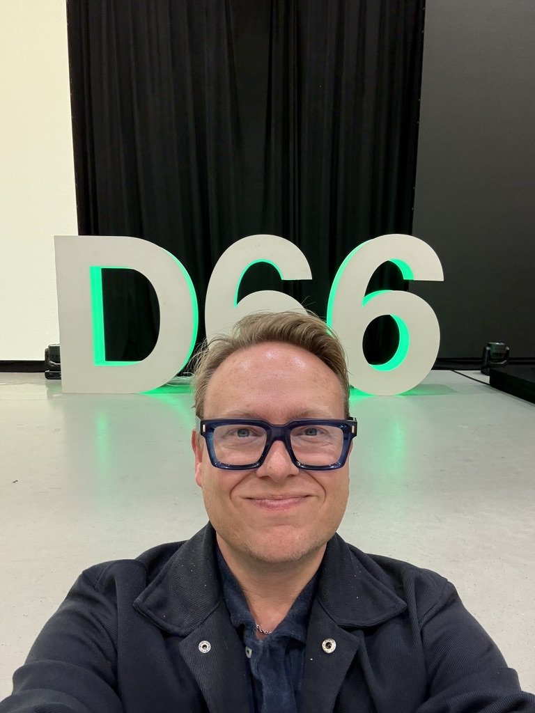 Een selfie van Benjamin Buurman voor grote 'D66'-letters op een partijcongres.