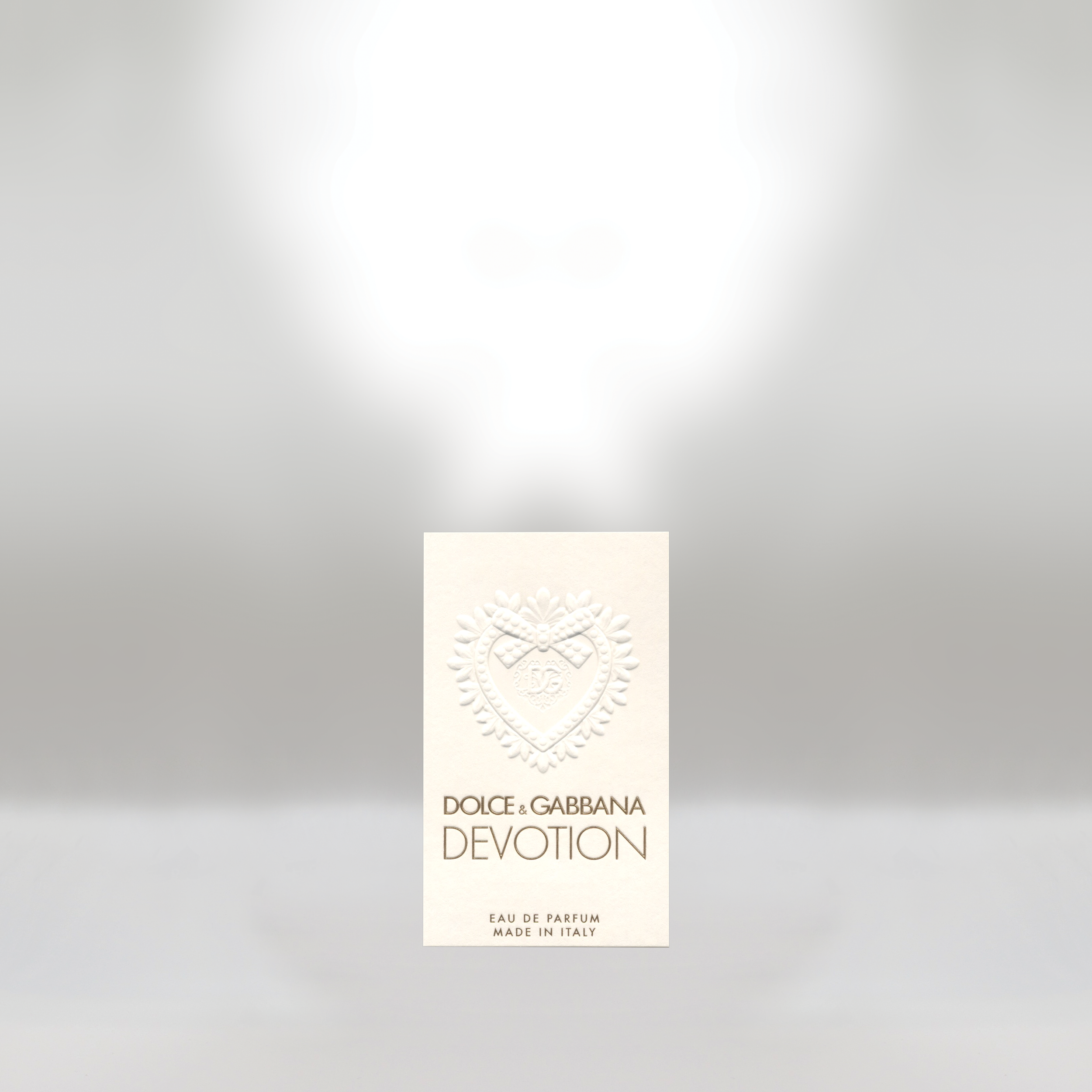 Package of Dolce & Gabbana Devotion Eau de Parfum with white embossed design and gold lettering.