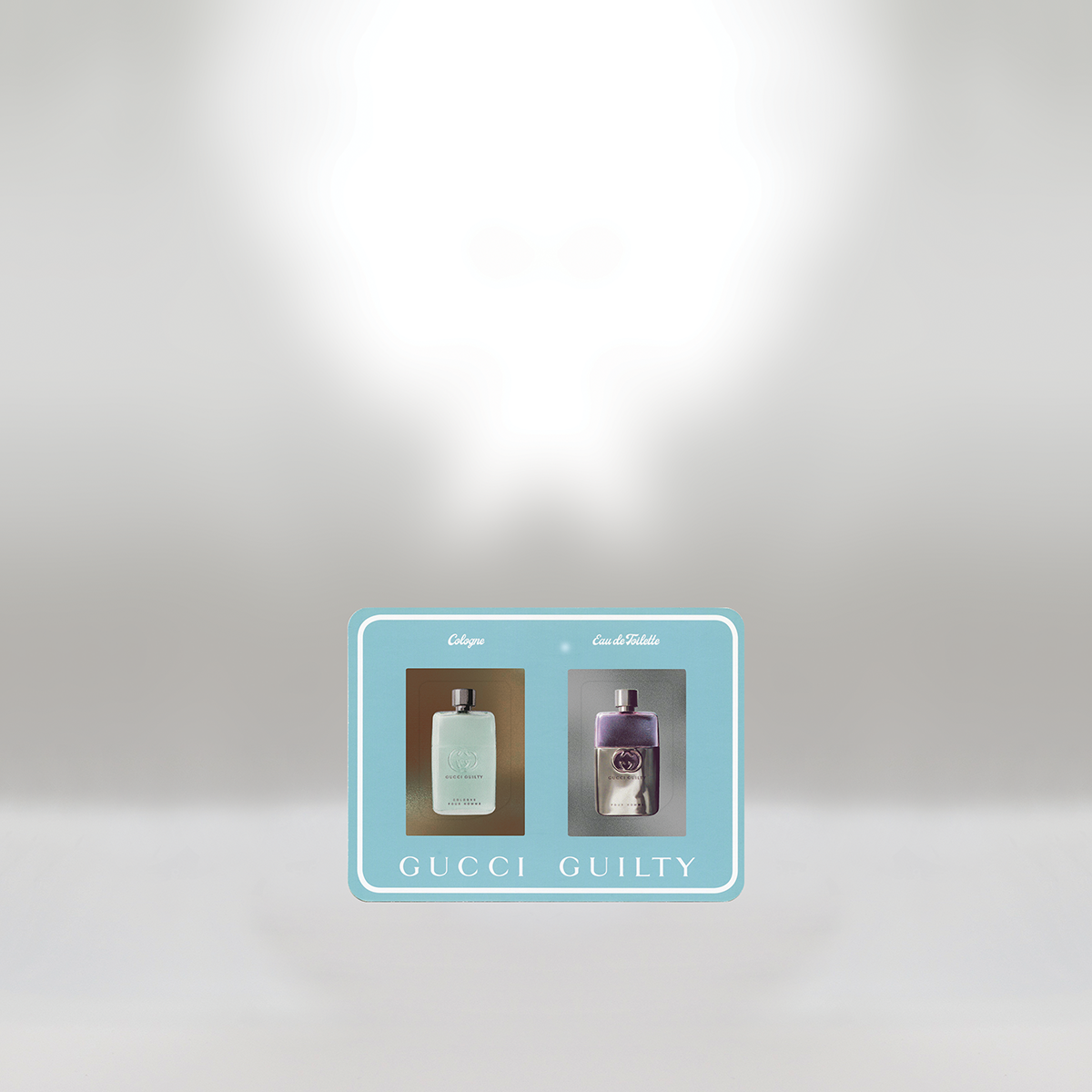 Gucci Guilty perfume promotion showing two bottles of perfume, one labeled 'Cologne' and the other 'Eau de Toilette', on a blue rectangular card with white text.