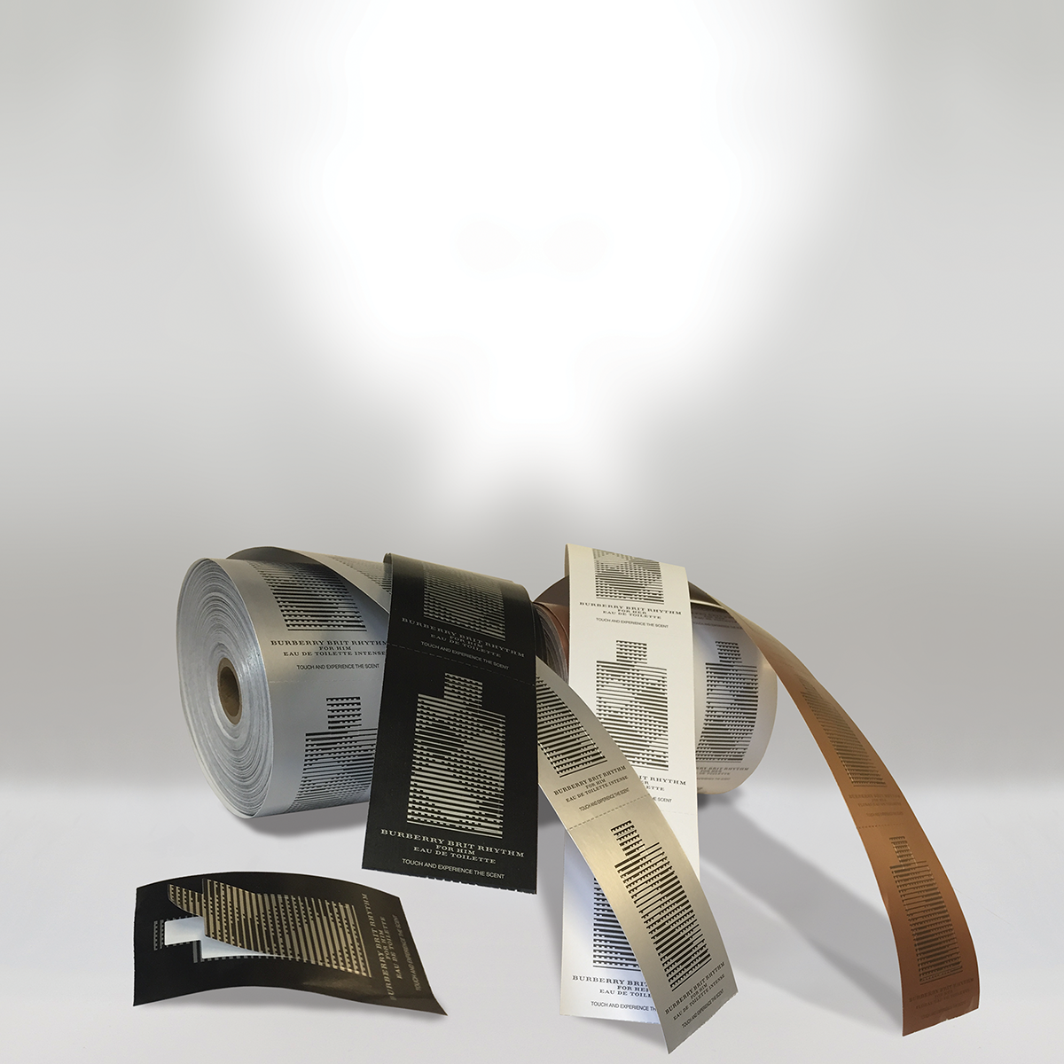 Spools of printed material with barcode patterns and text, some unspooled and laid out on a white surface.