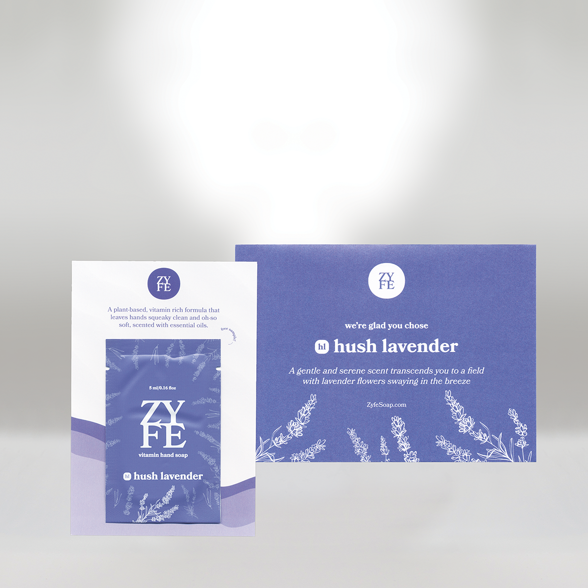 A box and a card of Zyfe Hush Lavender hand soap featuring purple and white packaging with lavender illustrations on a light gray background.