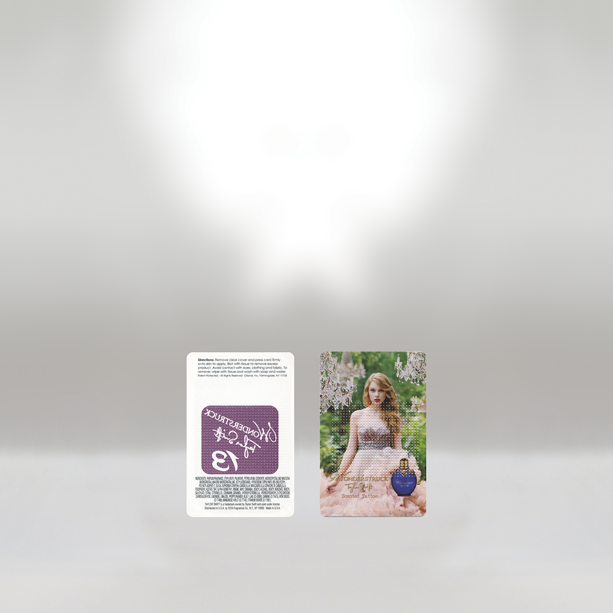 Product packaging featuring a woman with red hair in a garden setting, a perfume bottle, and a label with a purple background and white text.