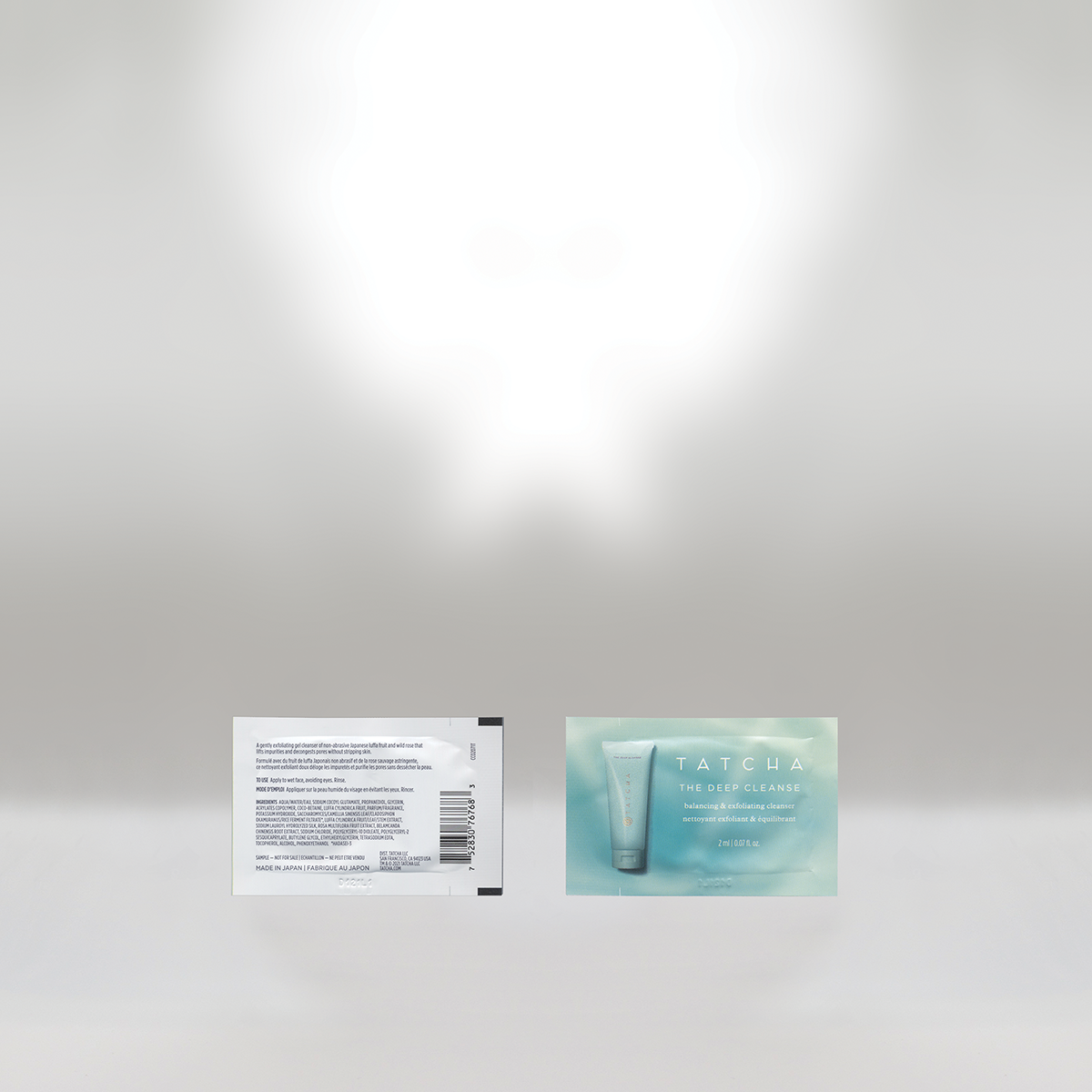 The image shows the front and back of a Tatcha skincare product package. The front has a light teal background with an image of a tube and the text 'Tatcha The Deep Cleanse balancing & exfoliating cleanser'. The back has detailed ingredients, barcode, and other product information.