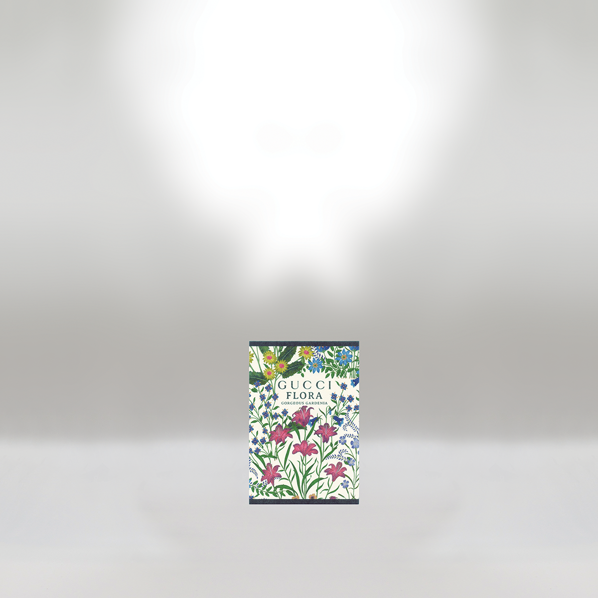 A Gucci Flora fragrance box with colorful floral illustrations, positioned on a plain grey background.