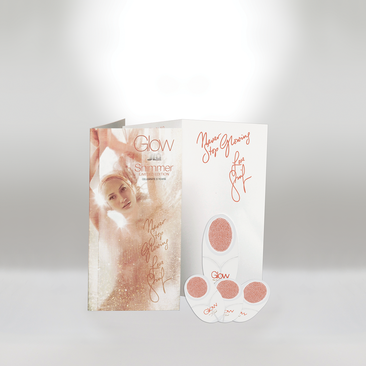 Beauty product package containing skin care patches and a brochure with a woman’s face, promotional text, and a motivational quote, all decorated in soft peach and white tones.