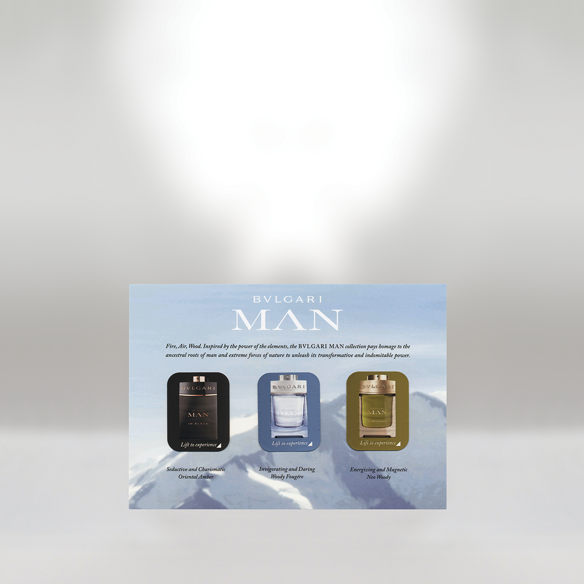 Advertisement for BVLGARI MAN fragrance collection showing three perfume bottles labeled in black, light blue, and green, with descriptions beneath each.