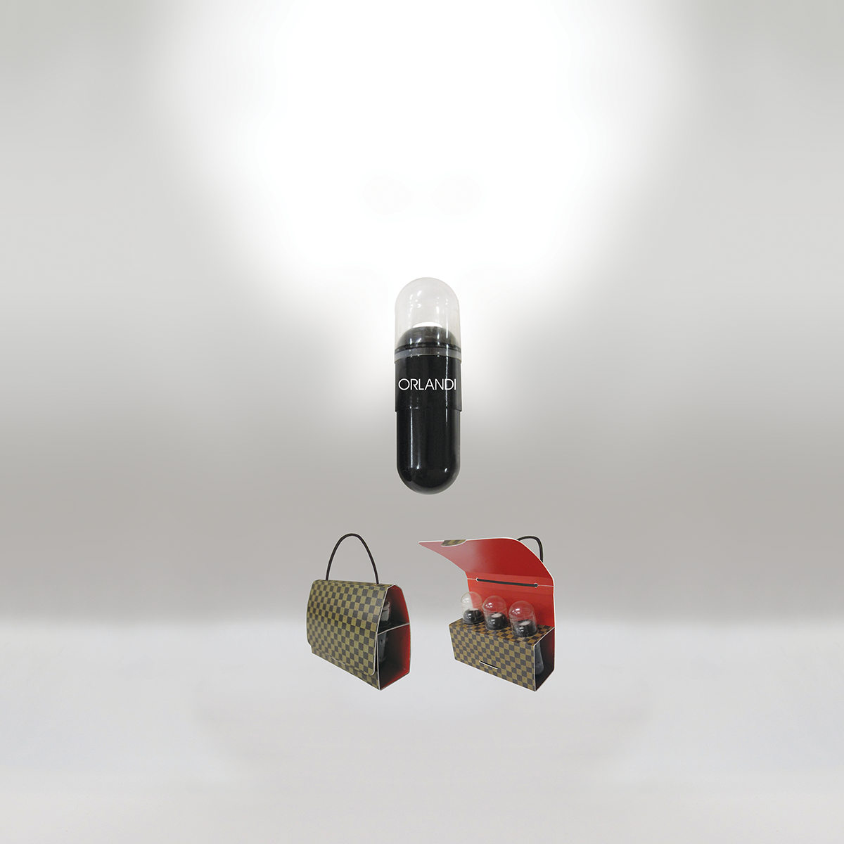 A black and transparent capsule with the label 'ORLANDI' floats above two fashion handbags and a display case with four small light bulbs inside.
