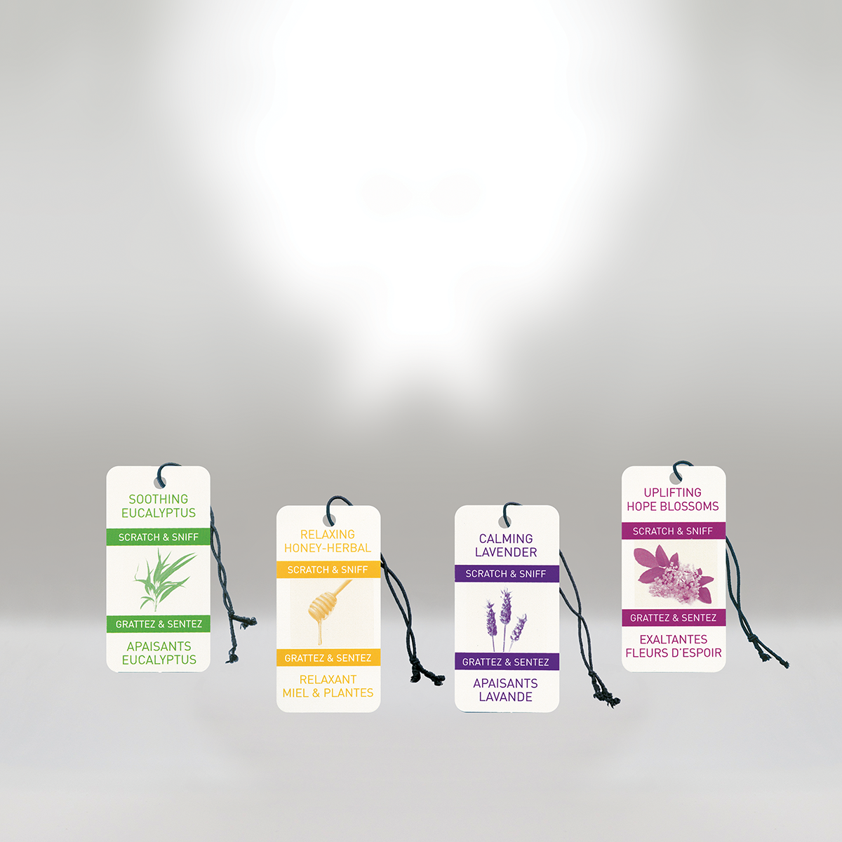 Four scented sachets, each with a label and a black string, hanging against a white background. The sachets are labeled as soothing eucalyptus, relaxing honey-herbal, calming lavender, and uplifting hope blossoms.
