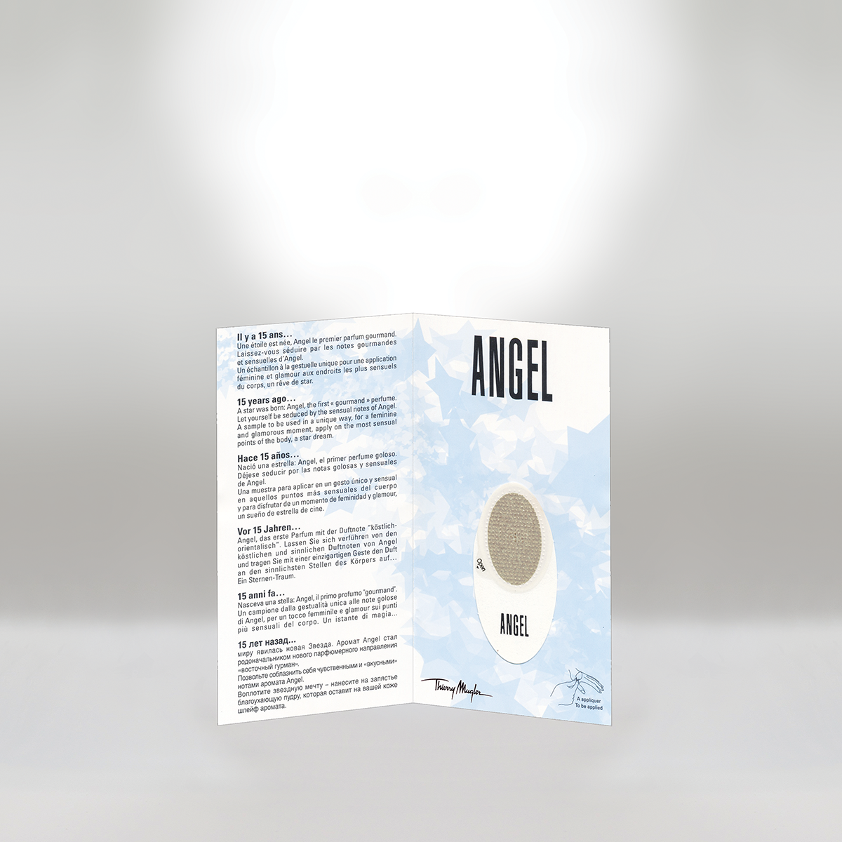 Tri-fold pamphlet about Angel perfume with a light blue starry background, a white perfume bottle illustration, and a signature by Thierry Mugler.