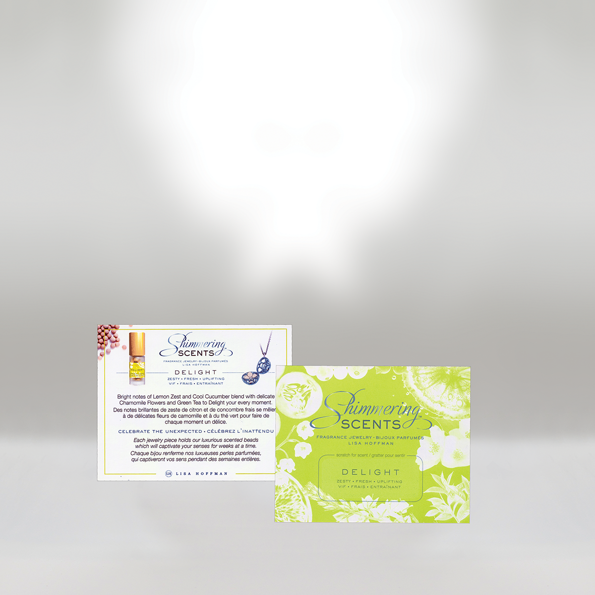 Two promotional cards for Shimmering Scents fragrances, one with a white background and the other green, featuring product descriptions and branding.
