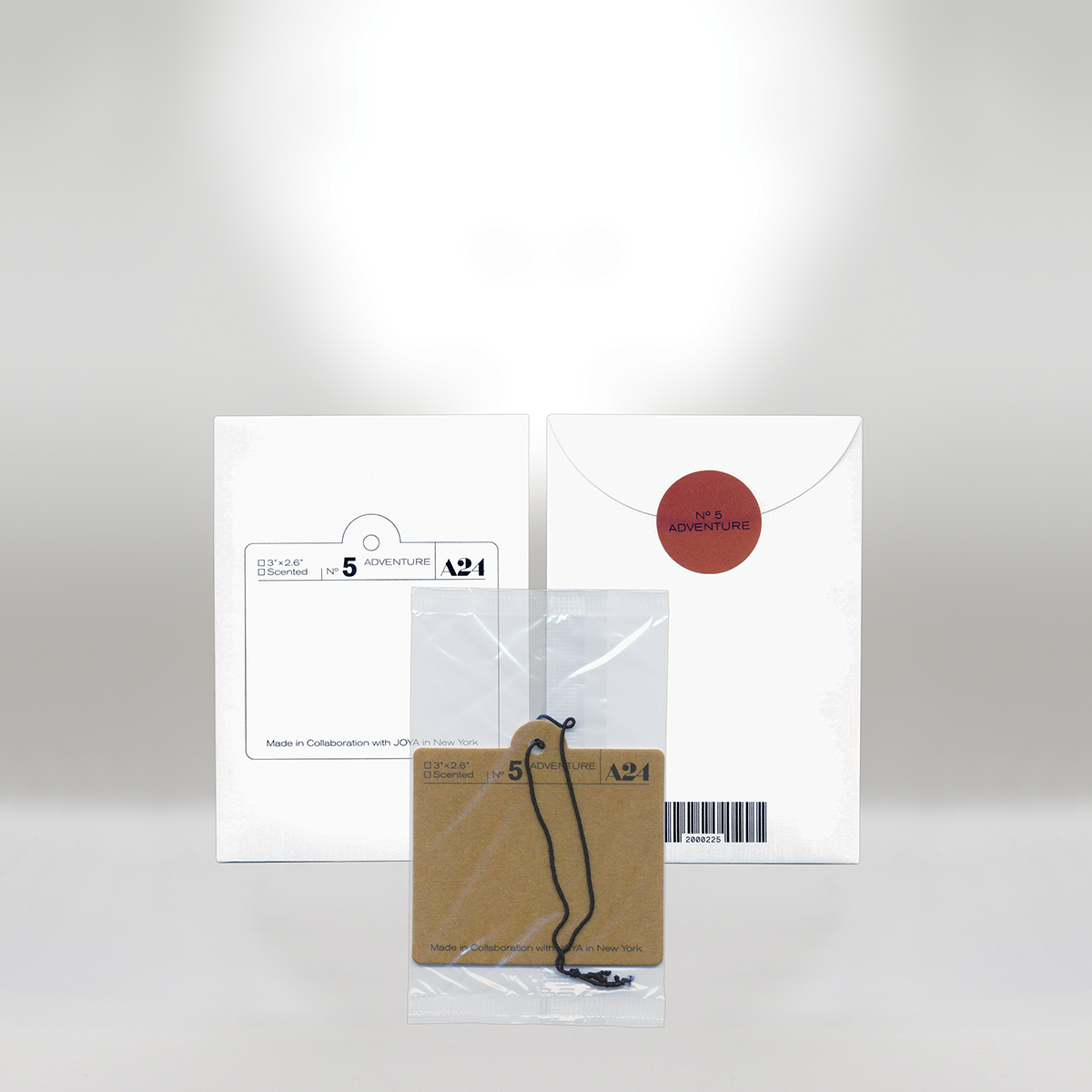 Set of stationery items including white packaging, a small plastic bag with a string, and tags labeled 'Adventure' and 'No 5'.