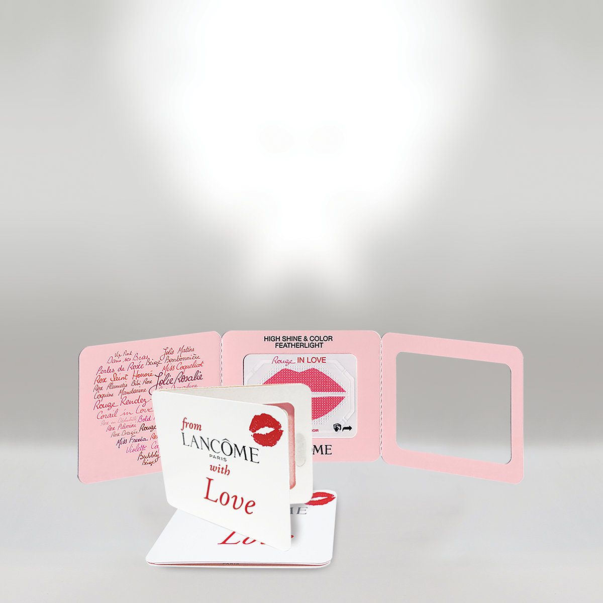 A Lancôme gift box with lipstick and love-themed packaging, including a booklet with lipstick shades and a mirror.