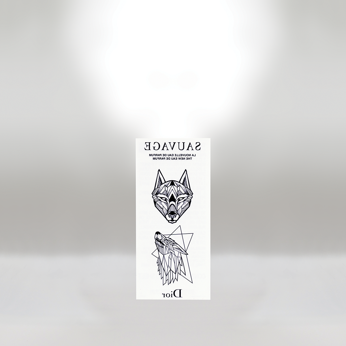 A white sticker with black line art of a wolf's head and a geometric wolf figure above the word "Dior." The sticker contains a message in French and English about revoking the fear of wolves and feral dogs, with the phrase "Sauvage" at the top.