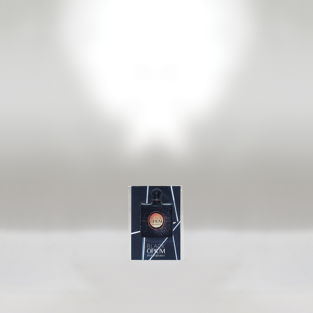 A YSL Black Opium perfume sample card with a small black perfume bottle on a white background.