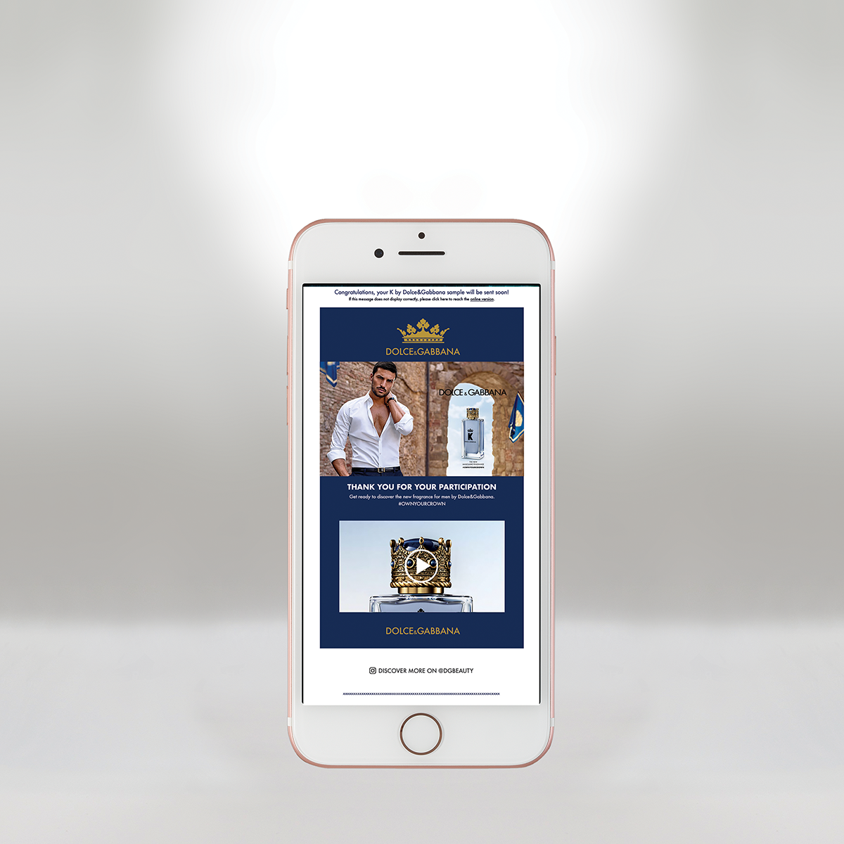 iPhone affichant un message promotionnel de Dolce & Gabbana remerciant les participants, avec un homme en chemise blanche et des images de flacons de parfum et de bijoux.