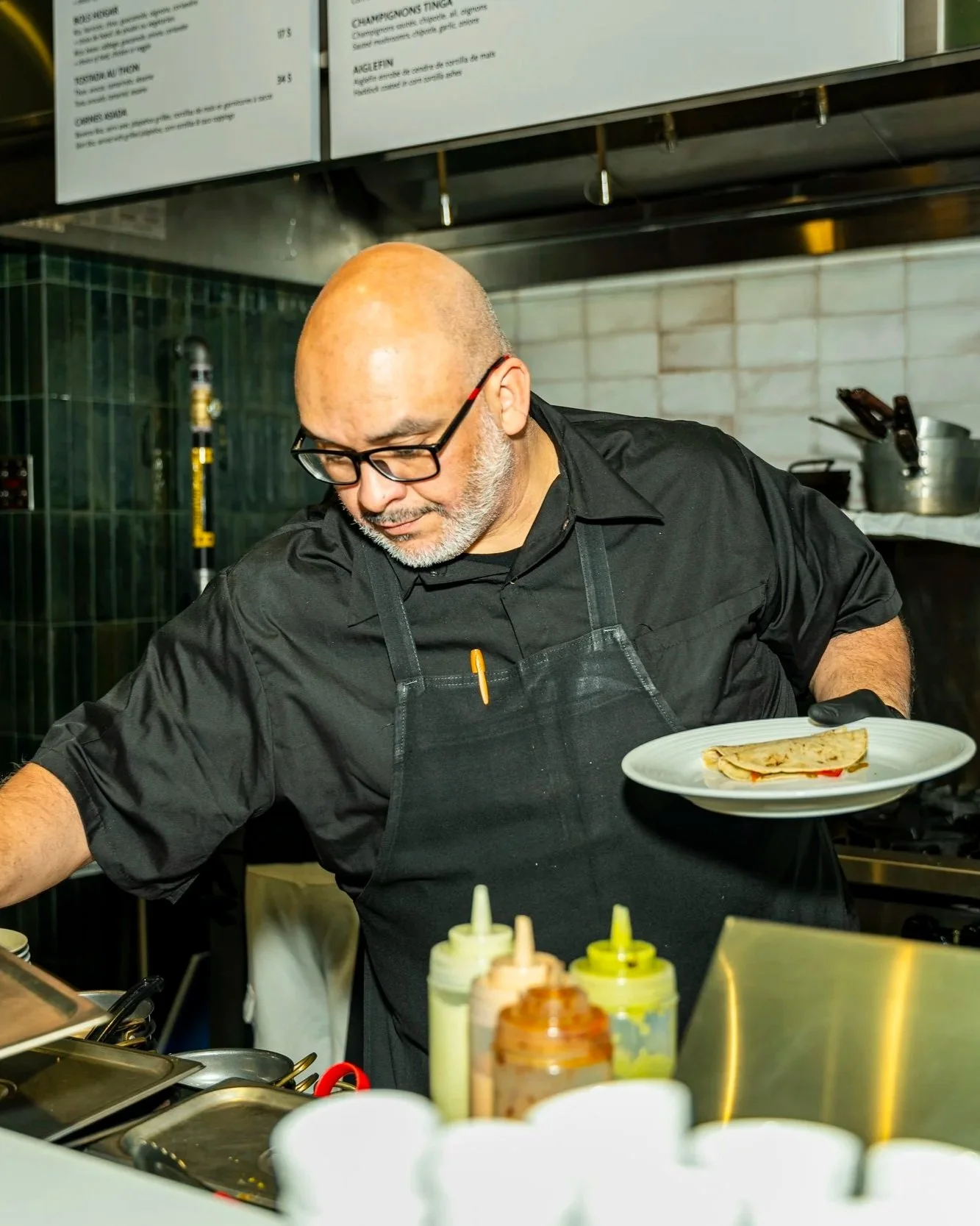 Chef preparing food à la minute at Le Fou Fou food hall Montreal — visible cooking design