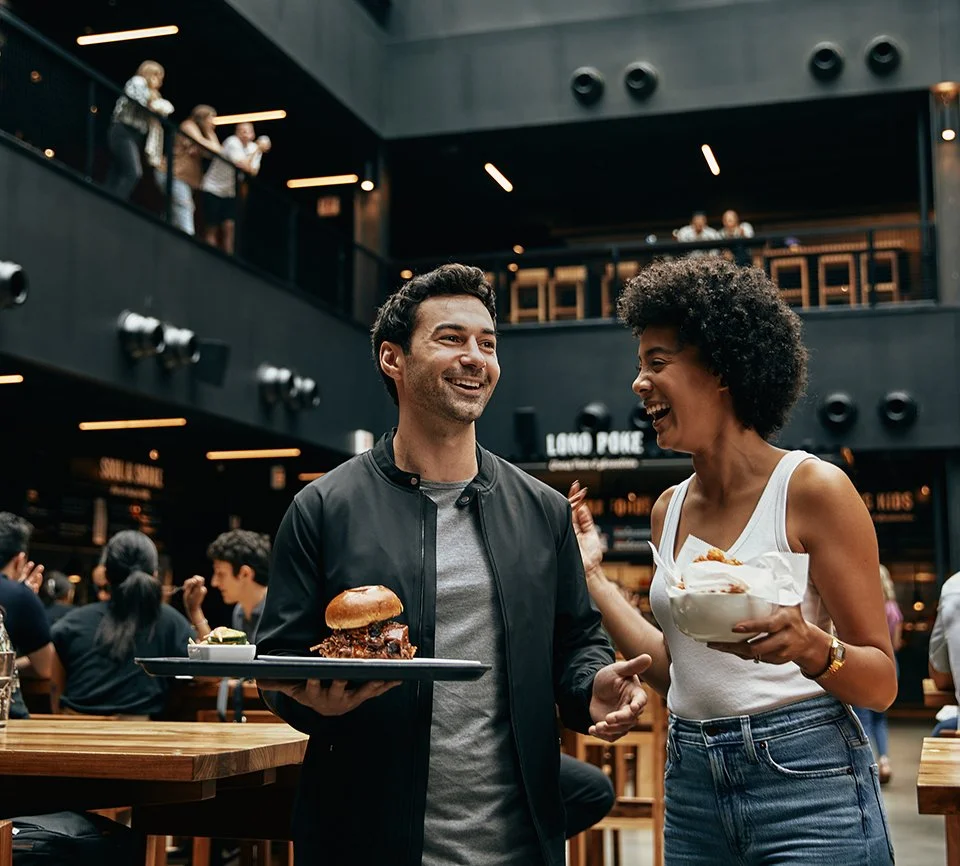 Couple smiling and laughing and holding a tray of food