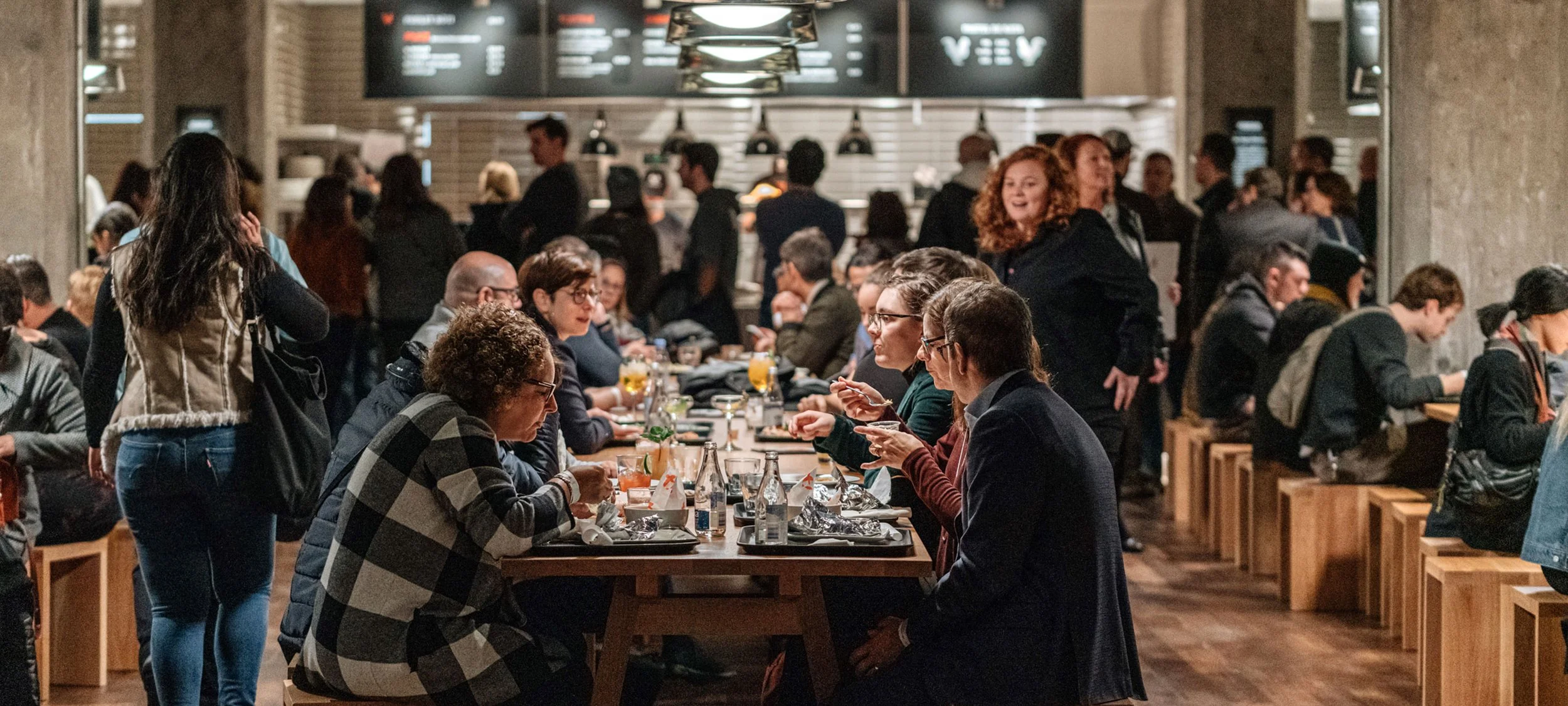 A busy food hall with people eating and socializing