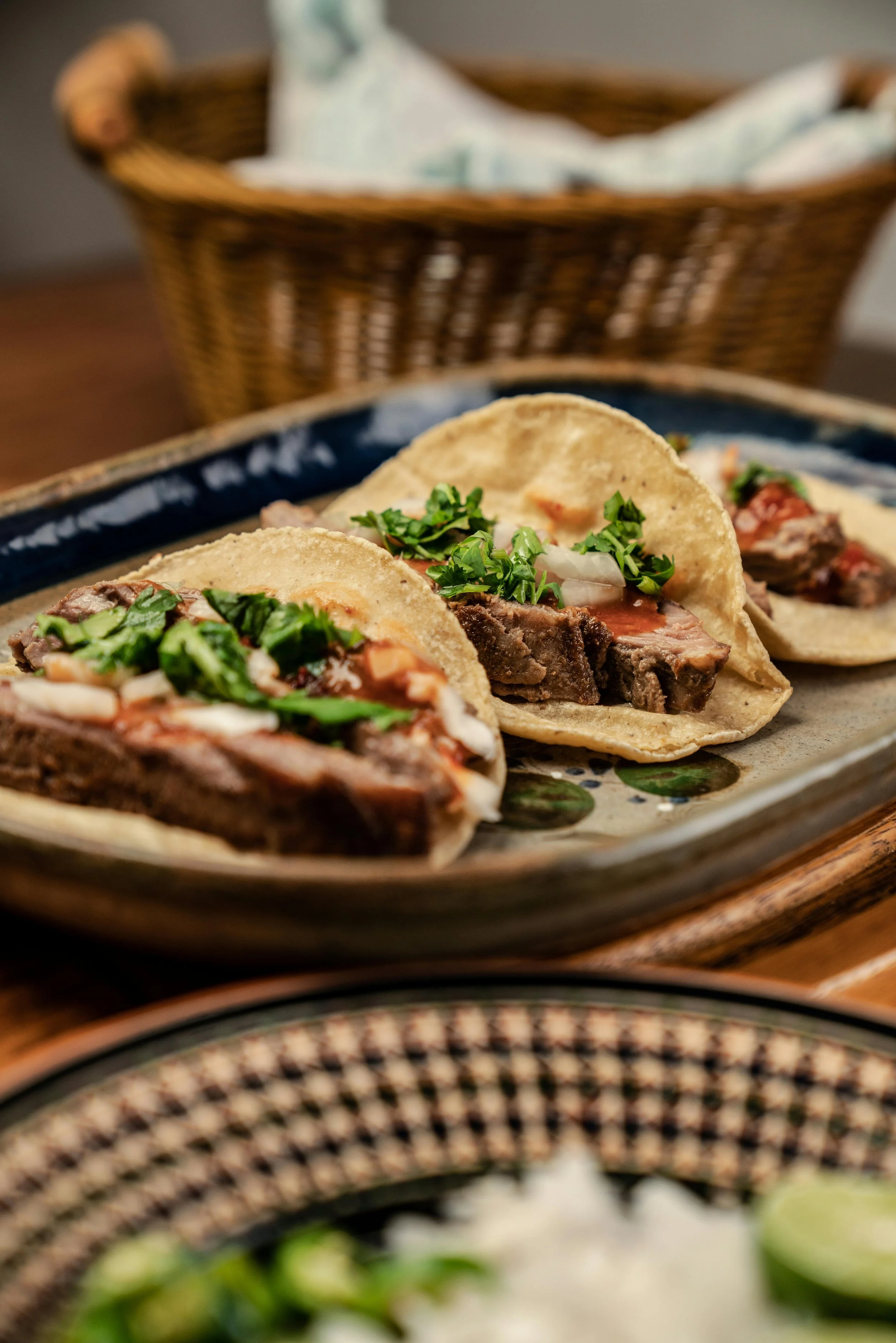 Picture of three steak tacos on a earthenware platter