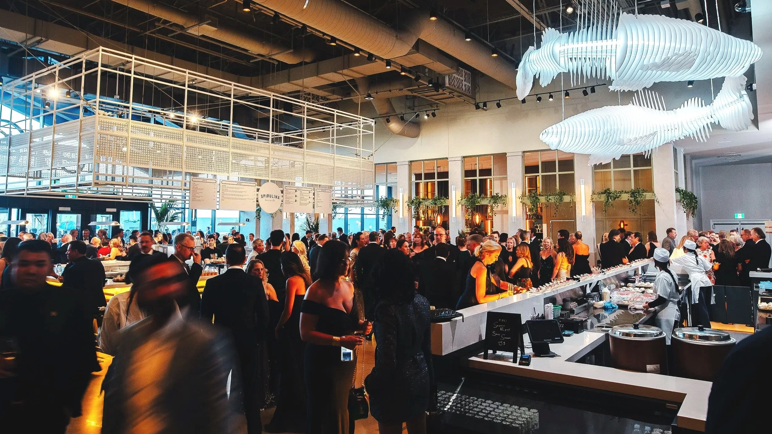 Image of busy food hall with fish lighting fixtures.