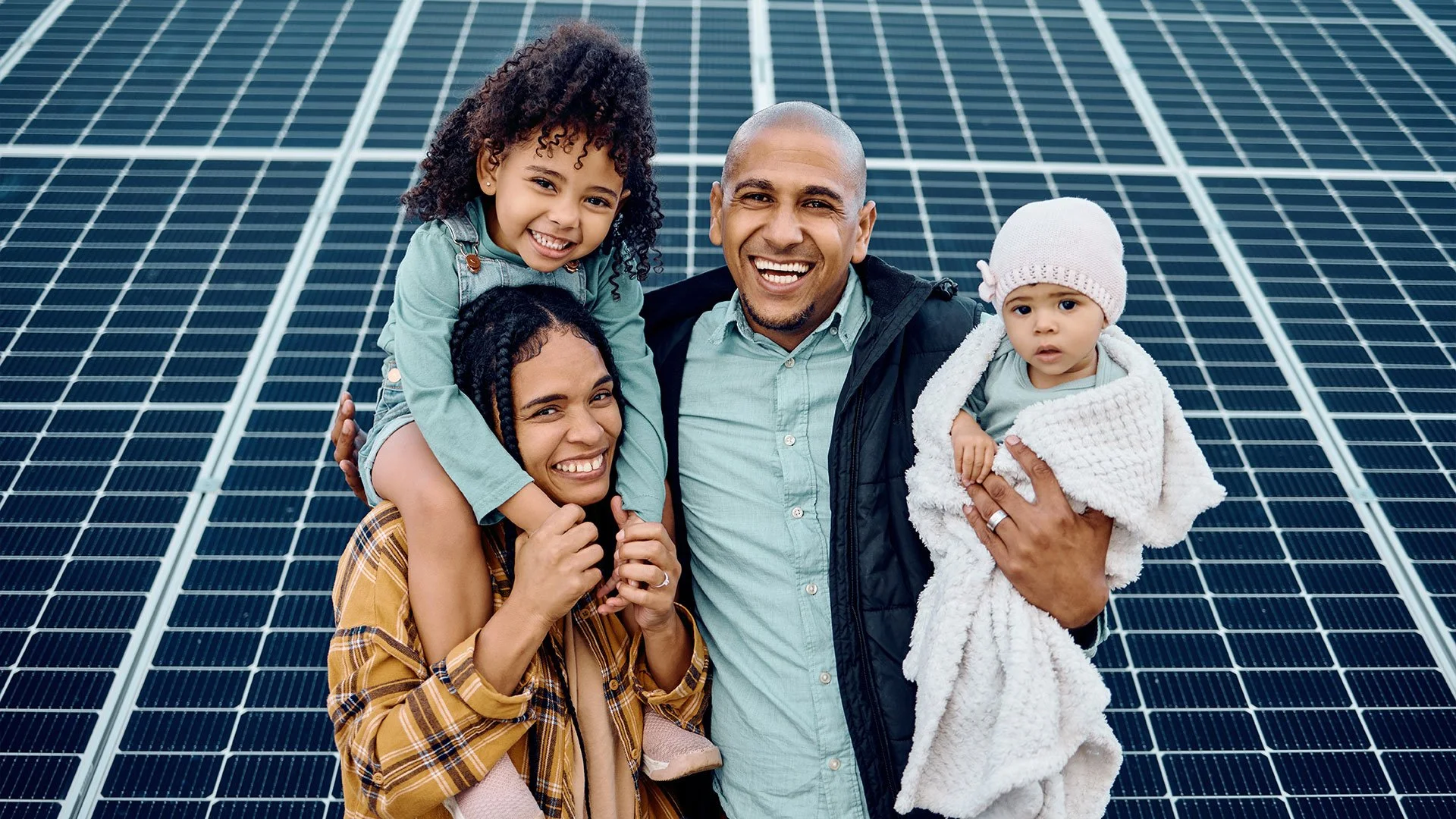 A happy family in front of solar panels.