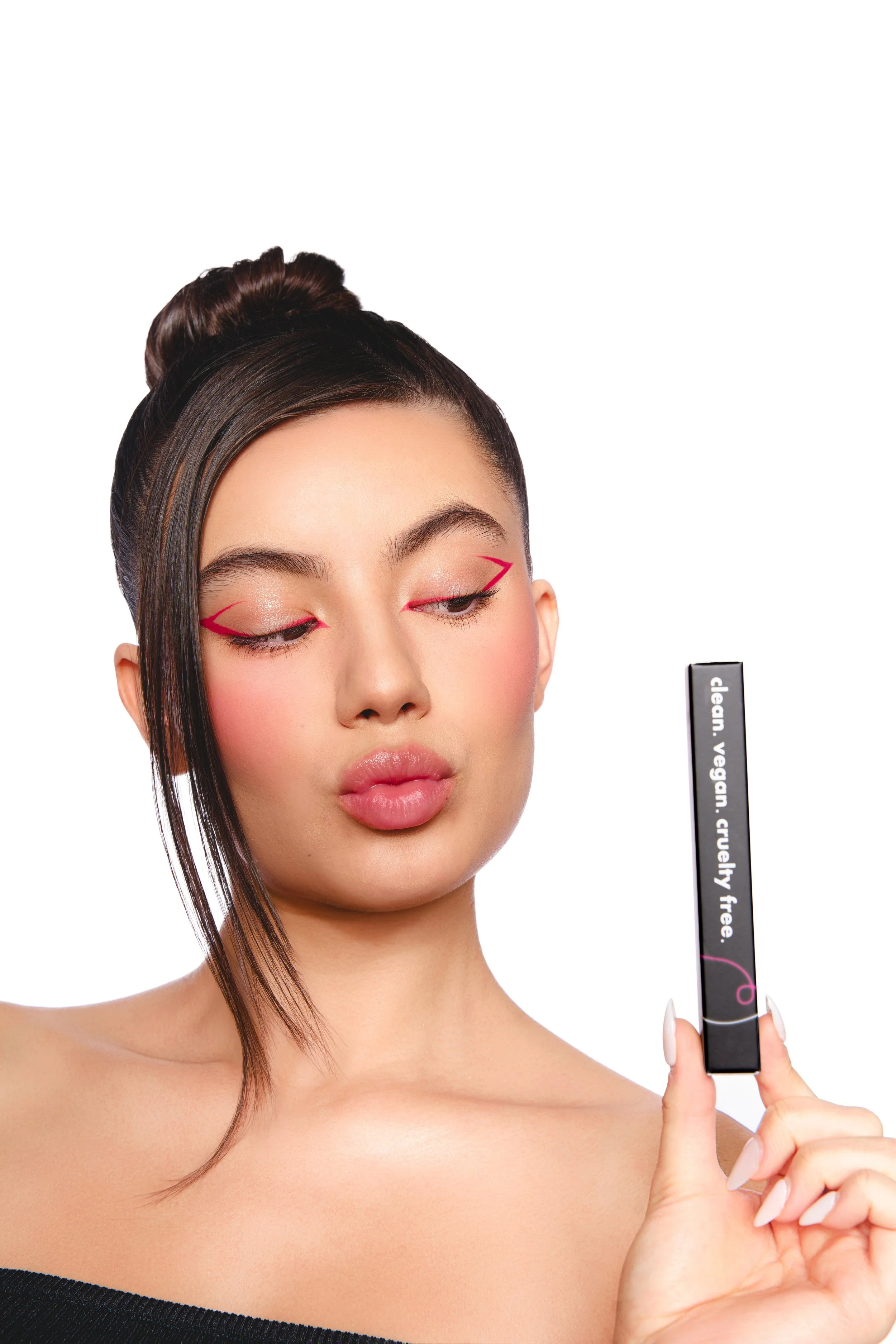 A woman with styled hair and makeup, holding a lipstick tube with the words 'clean, vegan, cruelty free' written on it.
